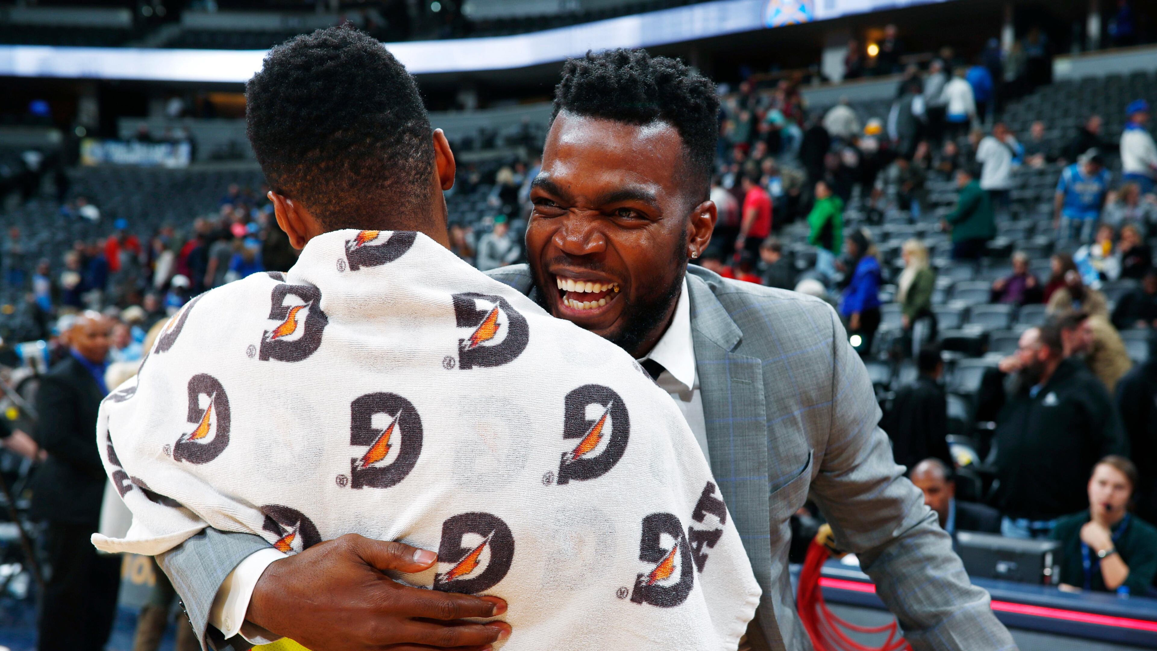 Injured Denver Nuggets forward Paul Millsap, back, hugs a former teammate, Atlanta Hawks guard Kent Bazemore, after an pNBA basketball game Wednesday, Jan. 10, 2018. Atlanta won 110-97. (AP Photo/David Zalubowski)