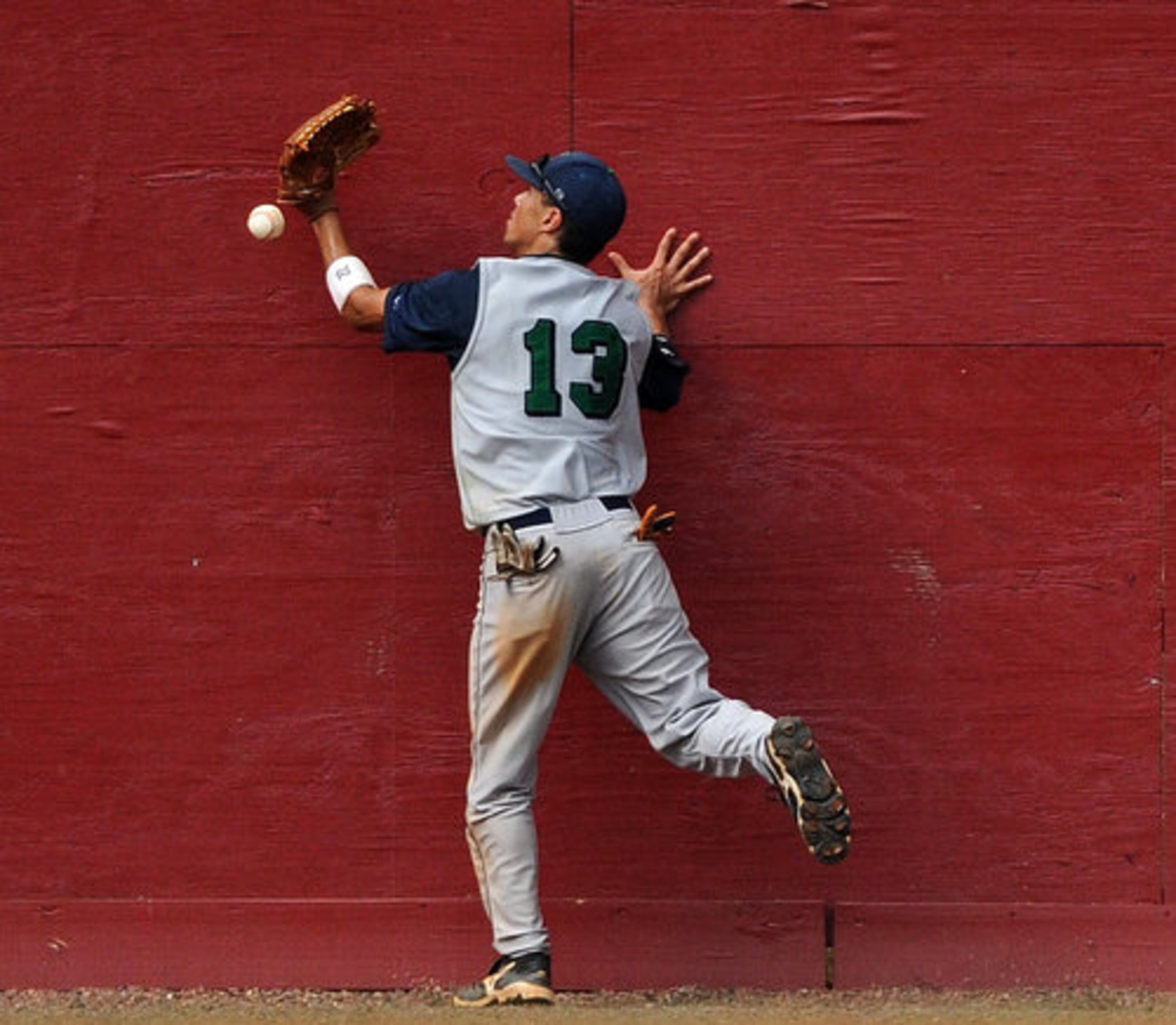 Harrison High School's Michael Hodorowski drops the ball after hitting the wall at Lassiter High School.