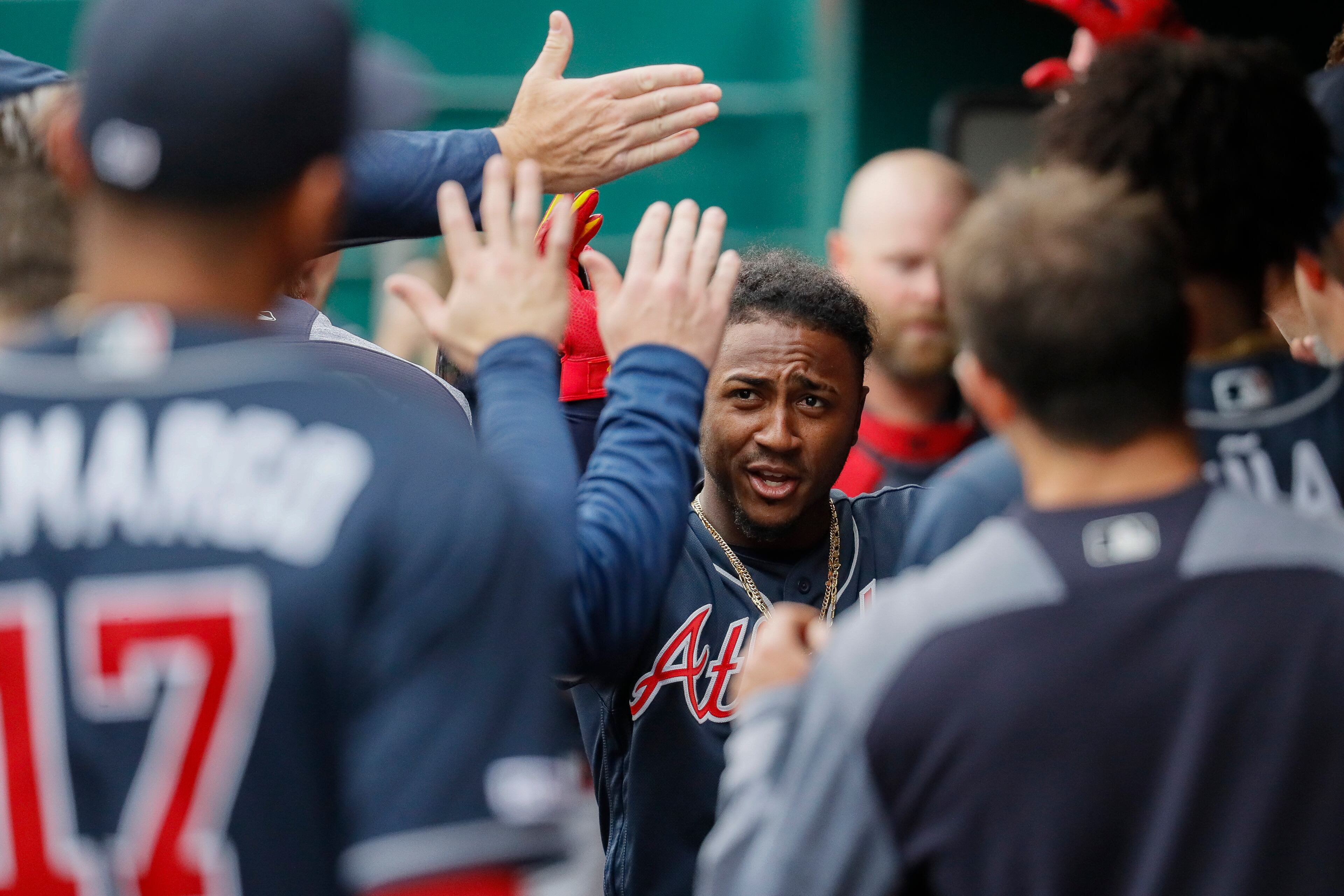 Atlanta Braves' Ozzie Albies celebrates in the dugout after hitting a solo home run off the first pitch from Cincinnati Reds starting pitcher Tanner Roark in the first inning of a baseball game, Wednesday, April 24, 2019, in Cincinnati. (AP Photo/John Minchillo)