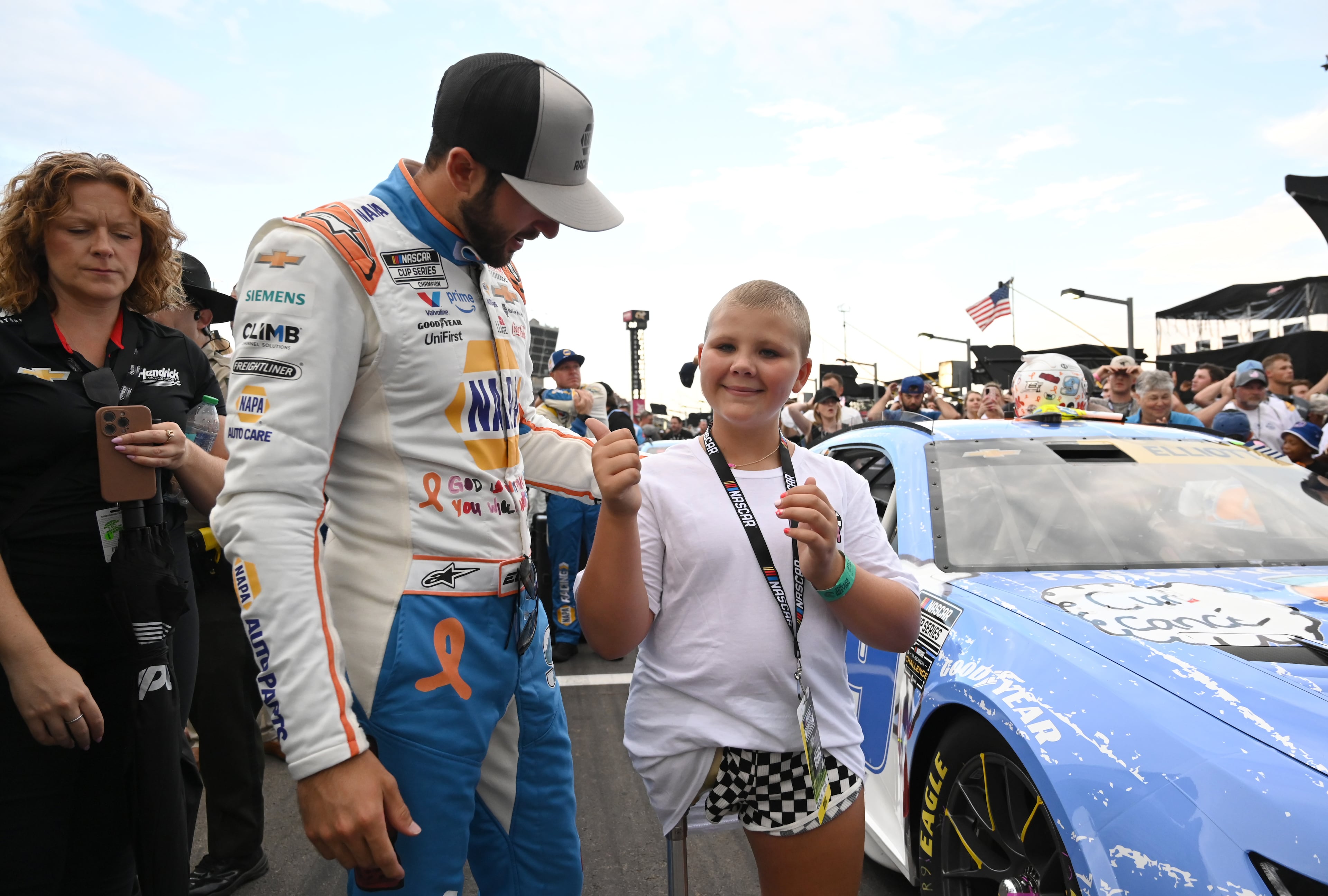 Rhealynn Mills, 11, gives a thumbs up as she talks with NASCAR Cup Series driver Chase Elliott before Quaker State 400 NASCAR Cup Series race at EchoPark Speedway, Saturday, June 28, 2025, in Hampton. 11-year-old Rhealynn Mills recently won a contest for her artwork to appear on NASCAR driver Chase Elliott's car. (Hyosub Shin / AJC)