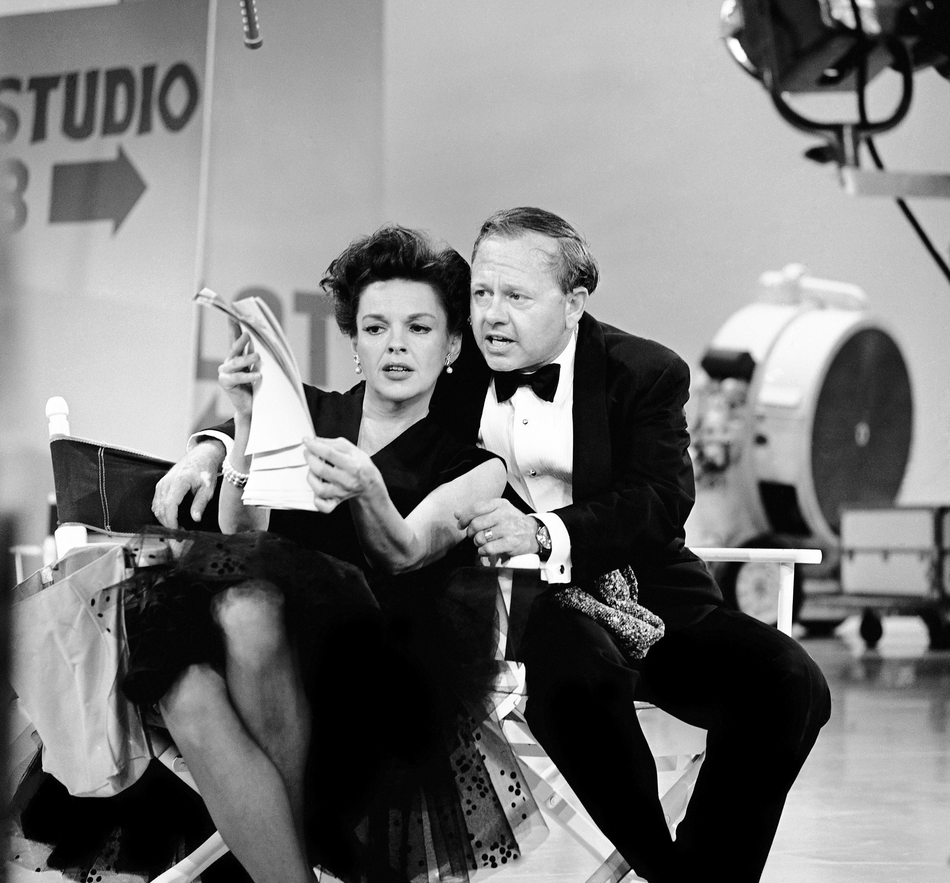 In this June 26, 1963, file photo, Judy Garland and Mickey Rooney put their heads together over a television script for their first onstage reunion in 18 years, for the taping of the first of 32 variety shows which Garland will do for CBS next season. Rooney, a Hollywood legend whose career spanned more than 80 years, has died. He was 93. Los Angeles Police Commander Andrew Smith said that Rooney was with his family when he died Sunday, April 6, 2014, at his North Hollywood home. (AP Photo/File)