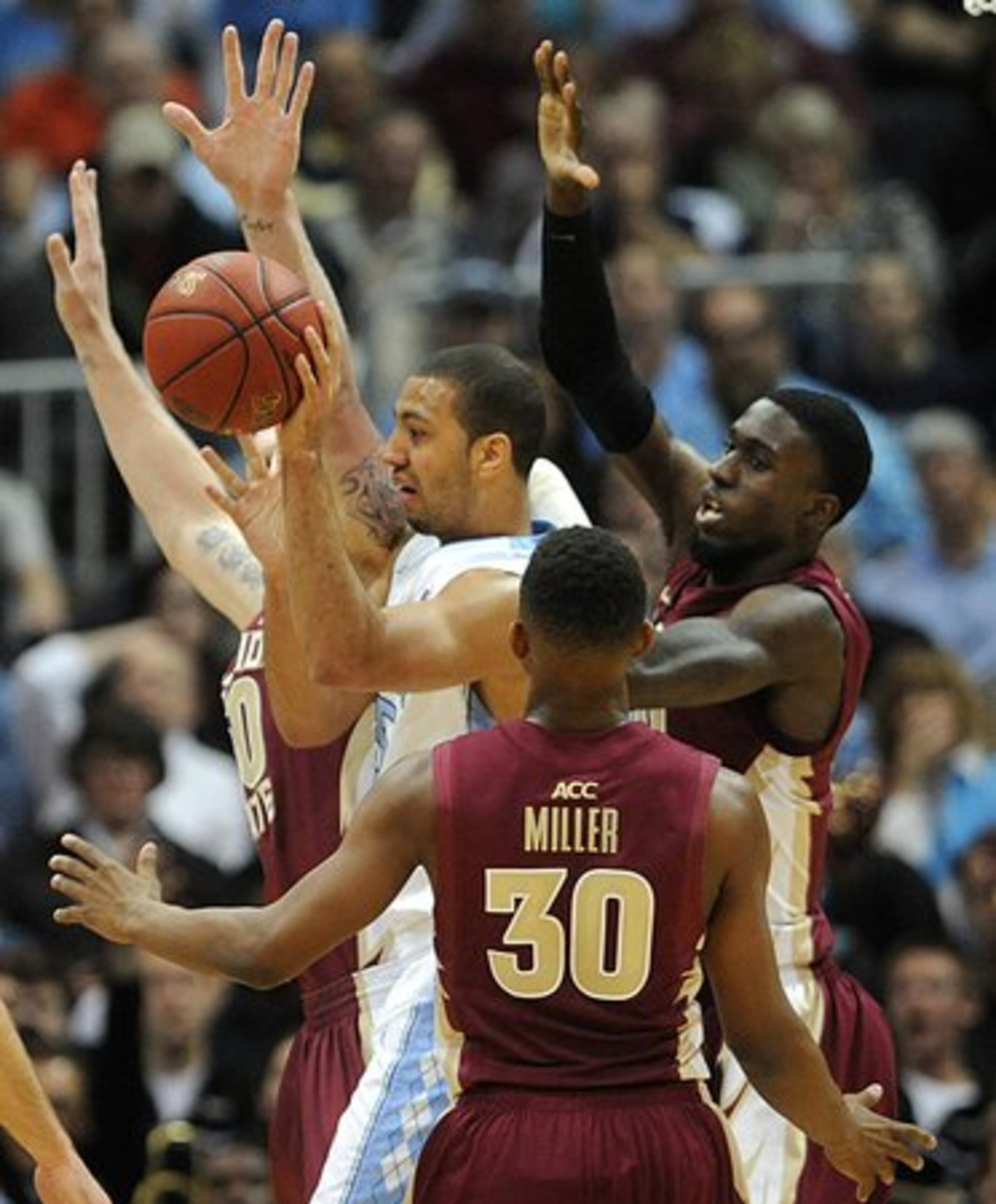 Florida State's Okaro White and Ian Miller players play tight defense on North Carolina's Kendall Marshall in the second half of the 59th Annual ACC Basketball Championship game.