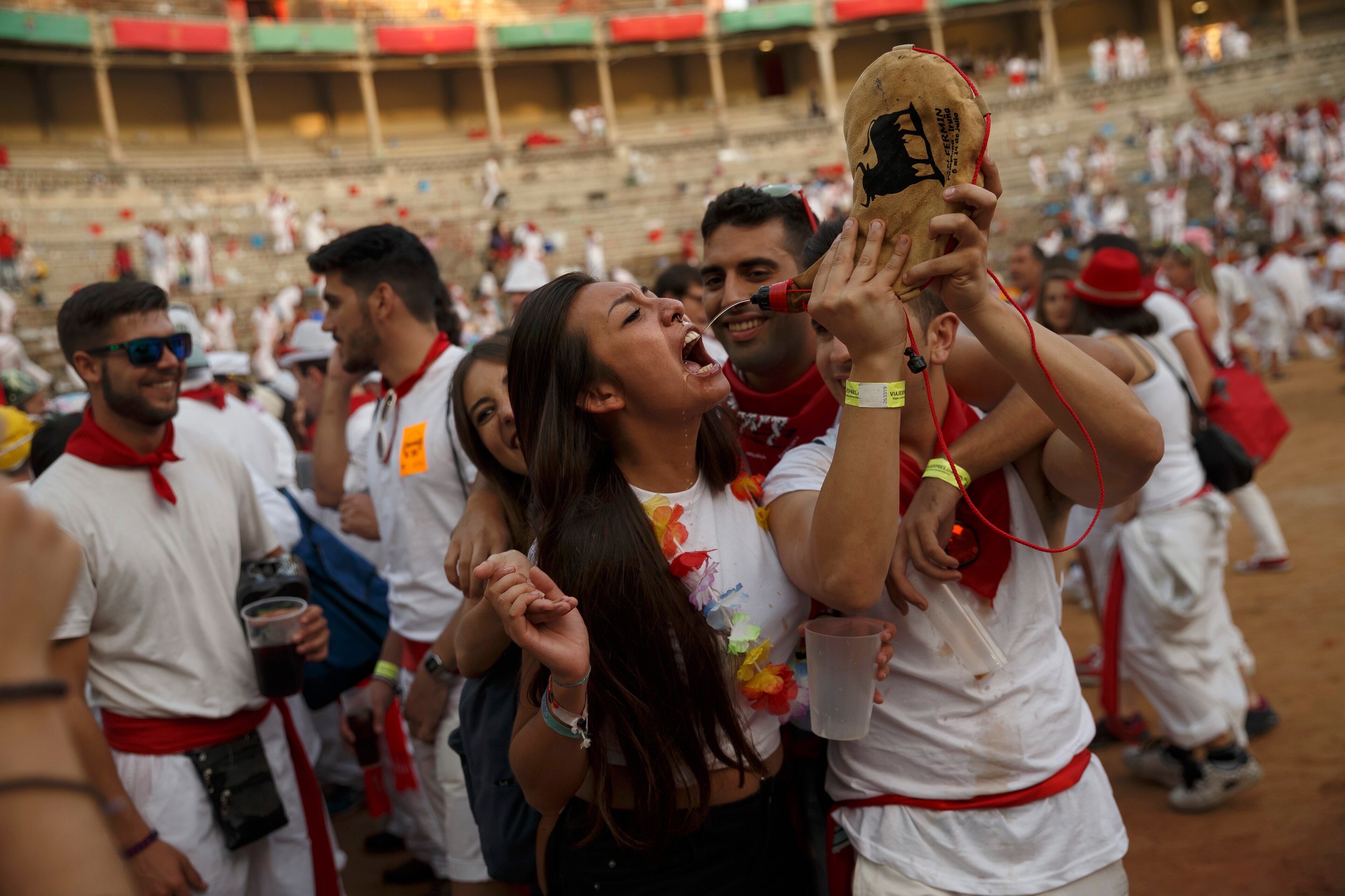 Revelers drink at the bullring's arena after the daily afternoon bullfight of the San Fermin festival in Pamplona, Spain, Saturday, July 11, 2015. Revelers from around the world arrive in Pamplona every year to take part in some of the eight days of party and the running of the bulls. (AP Photo/Daniel Ochoa de Olza)