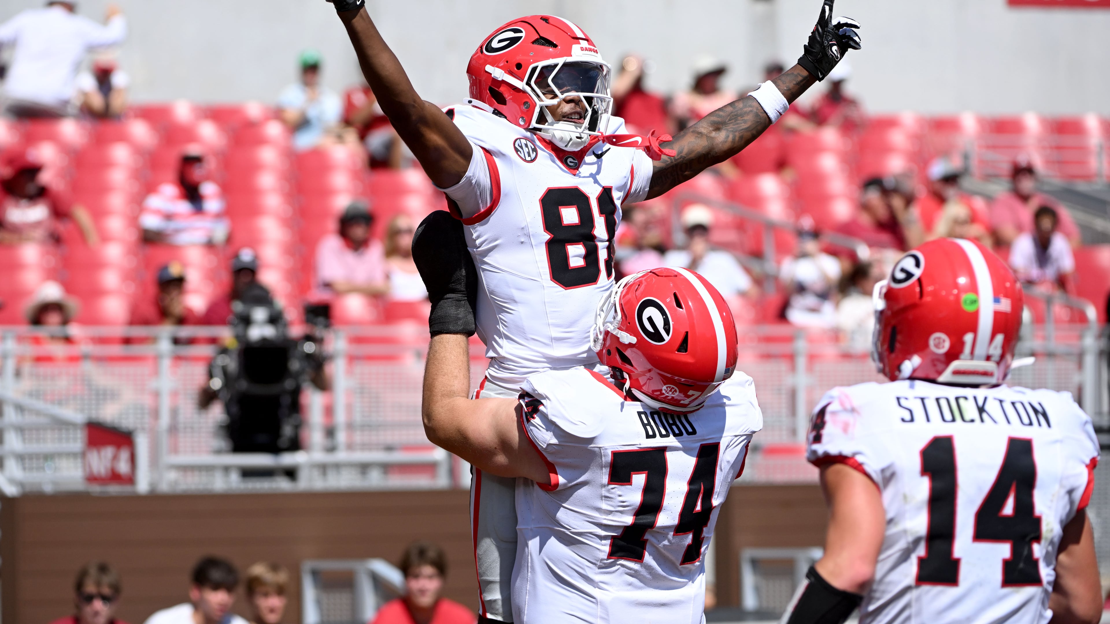 Georgia wide receiver Craig Dandridge (81) celebrates with teammates Drew Bobo (74) and Gunner Stockton (14) after a touchdown catch against Arkansas during the second half of an NCAA college football game Saturday, Sept. 19, 2026, in Fayetteville, Ark. (AP Photo/Michael Woods)