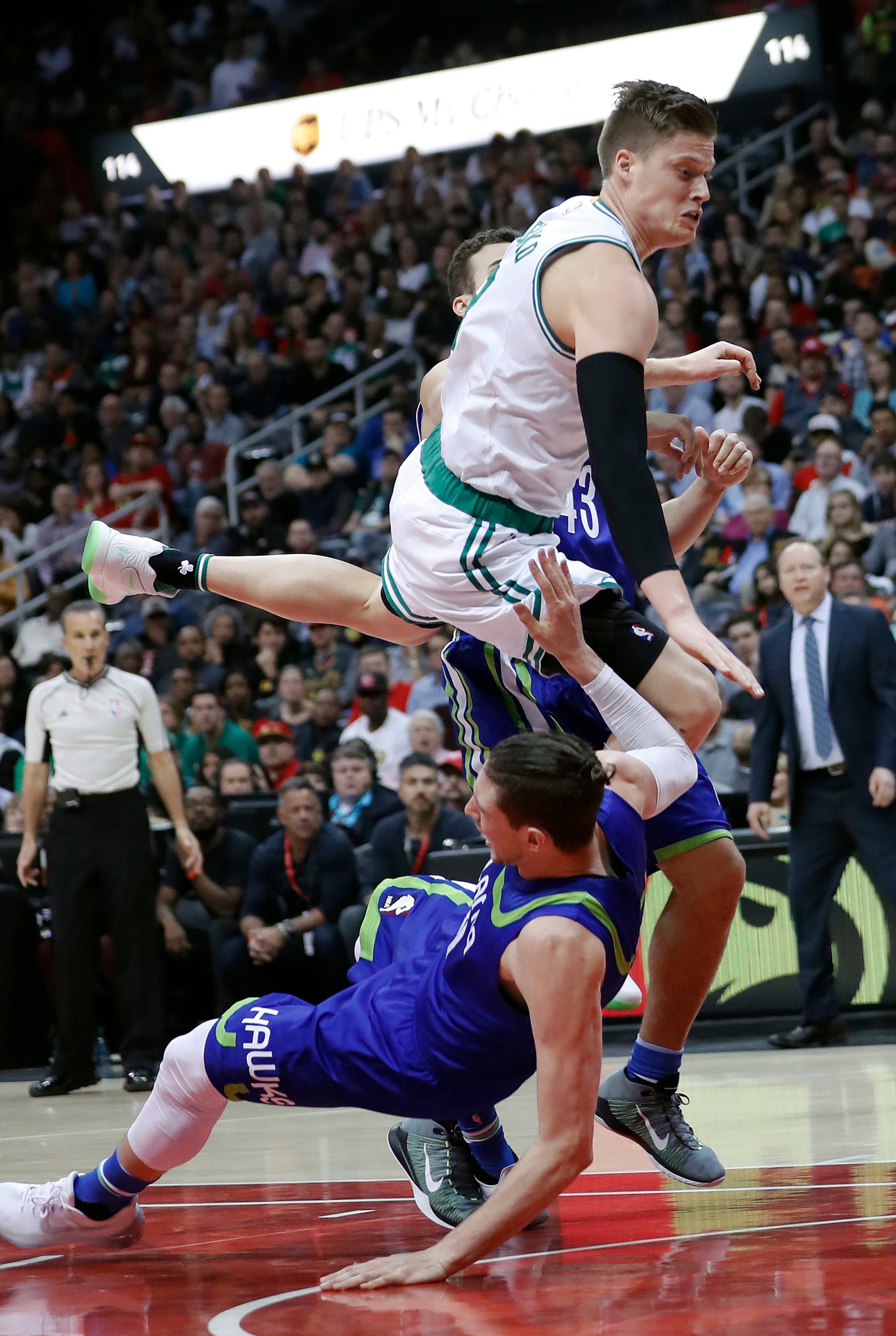 Boston Celtics forward Jonas Jerebko, top, fouls Atlanta Hawks forward Mike Muscala as he drives to the basket in the first half of an NBA basketball game Friday, Jan. 13, 2017, in Atlanta. (AP Photo/John Bazemore)