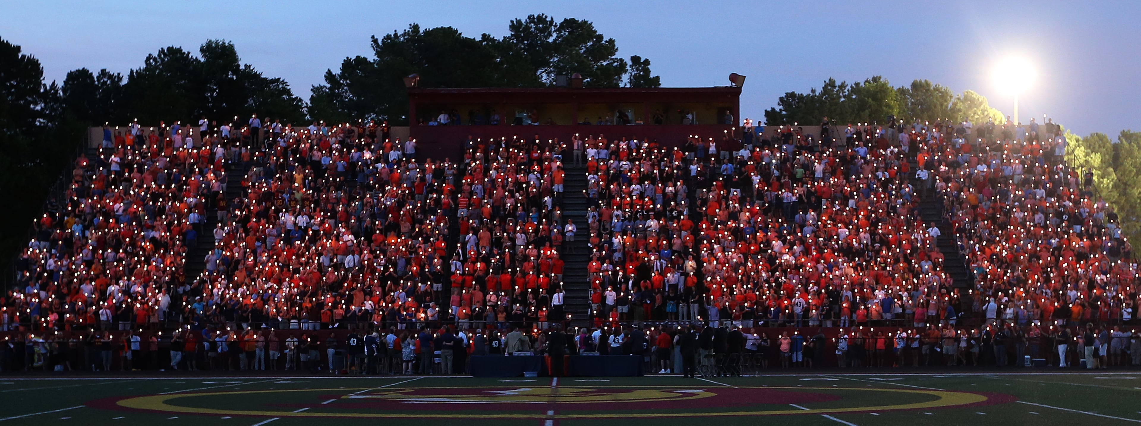 Friends, family, teammates and fans hold candles in memory of Philip Lutzenkirchen during a memorial service at Lassiter High School in east Cobb on Wednesday evening July 2, 2014. Lutzenkirchen was a star football player at Lassiter and Auburn who died in a car accident. BEN GRAY / BGRAY@AJC.COM