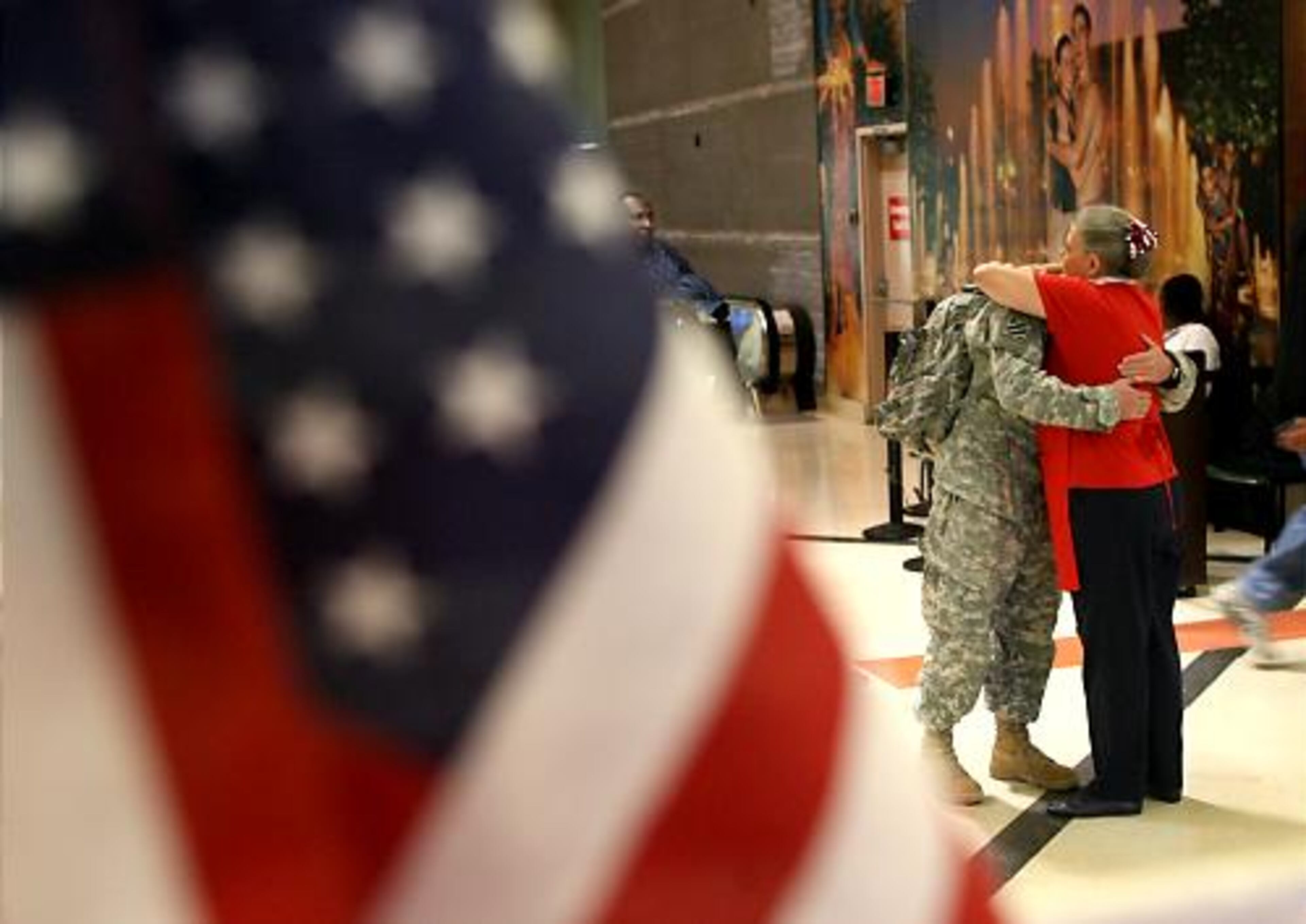 Army Pfc. Ian Doherty hugs USO volunteer Bette Rose Bowers after his flight from Maine to Atlanta.