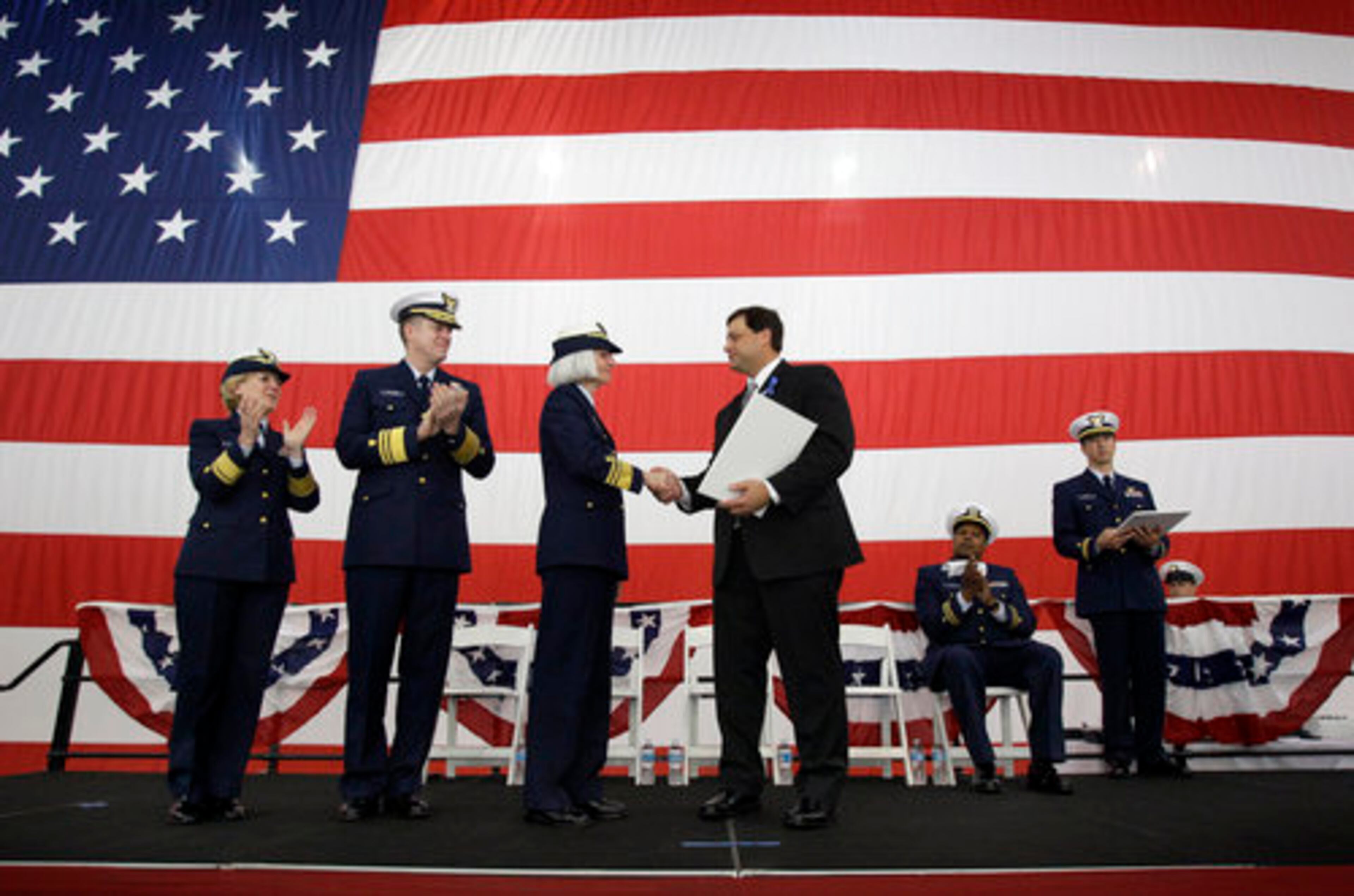 Alwin Landry, master of the offshore supply vessel Damon B. Bankston, seen at center with white folder, shakes hands with U.S. Coast Guard Vice Admiral Sally Brice-O'Hara after accepting a commendation during a ceremony honoring members of the vessel and Coast Guard helicopter crews who helped rescue 115 survivors of last year's Deepwater Horizon explosion at Coast Guard Air Station New Orleans in Belle Chasse, La., Friday, April 15, 2011.