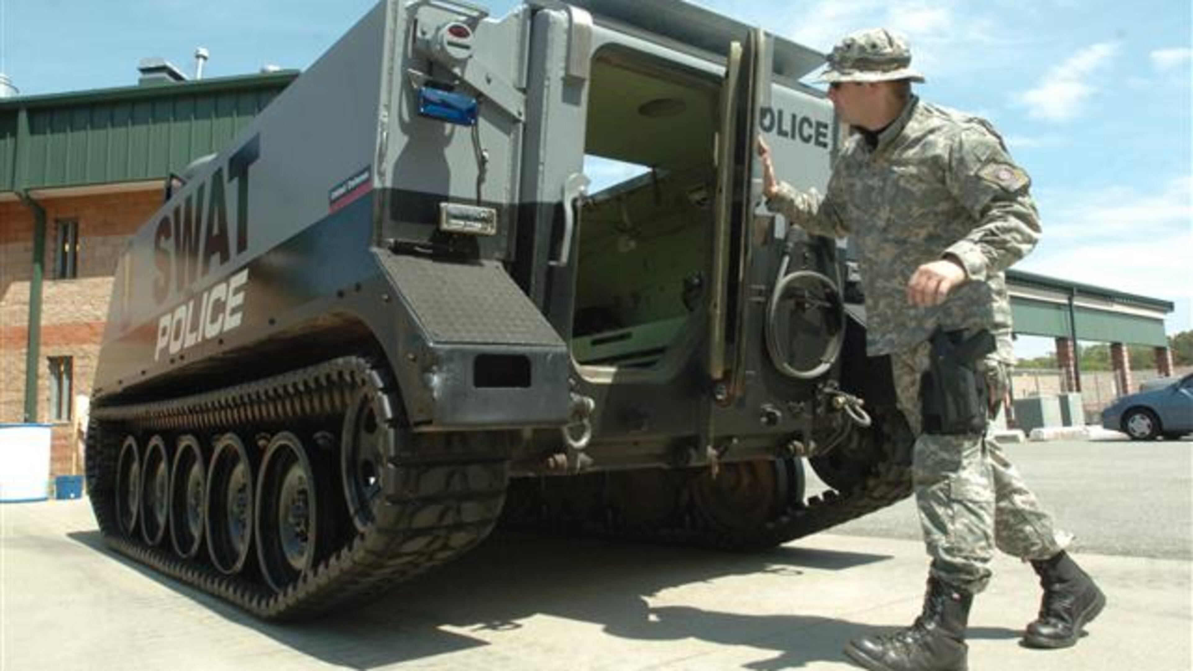 070410 Doraville Ga: Officer M. Joseph Shirley of the Doraville SWAT Perimeter Unit is an Operator of the M13 vehicle. He is giving the photographer a tour of the M13. Georgia police benefit from Pentagon surplus equipment program. Law enforcement agencies in small Georgia communities benefit from a Pentagon program in which these departments can get at no cost everything from helicopters and armored vehicles to uniforms, weapons and boots. The program re-uses excess material purchased by the taxpayers without the locals having to pay out more for big-ticket items that normally would be out of reach for many small-town budgets. April 10, 2007 (Renee' Hannans Henry/Staff). Police have been obtaining surplus military equipment for years. The AJC photo archives contains this picture from 2007 of Doraville police with a M13 vehicle.