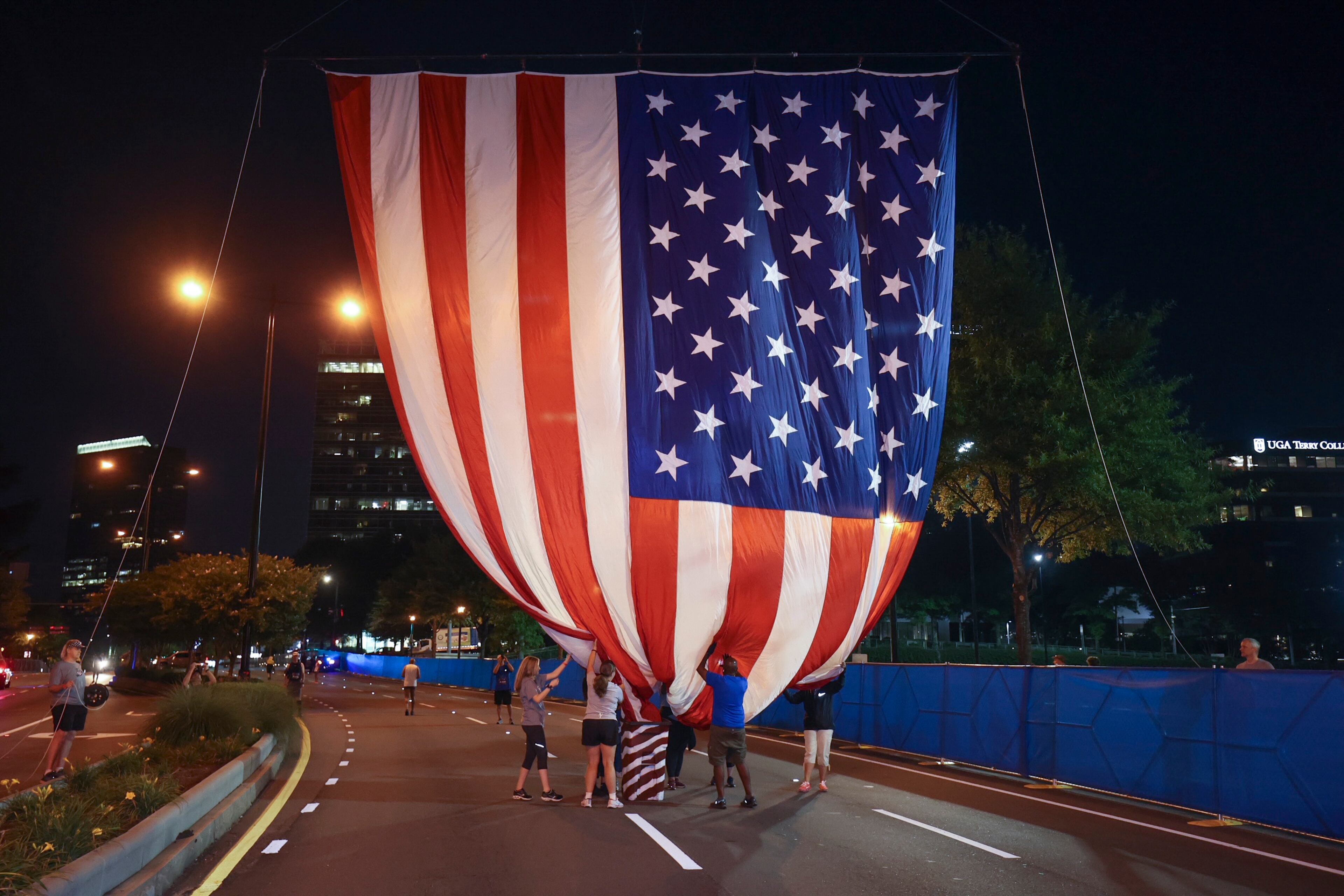 7/3/21 - Atlanta, GA - Volunteers raise the flag at the start as the AJC Peachtree Road Race returned in-person Saturday for the holiday tradition. (Jason Getz for the Atlanta Journal-Constitution)