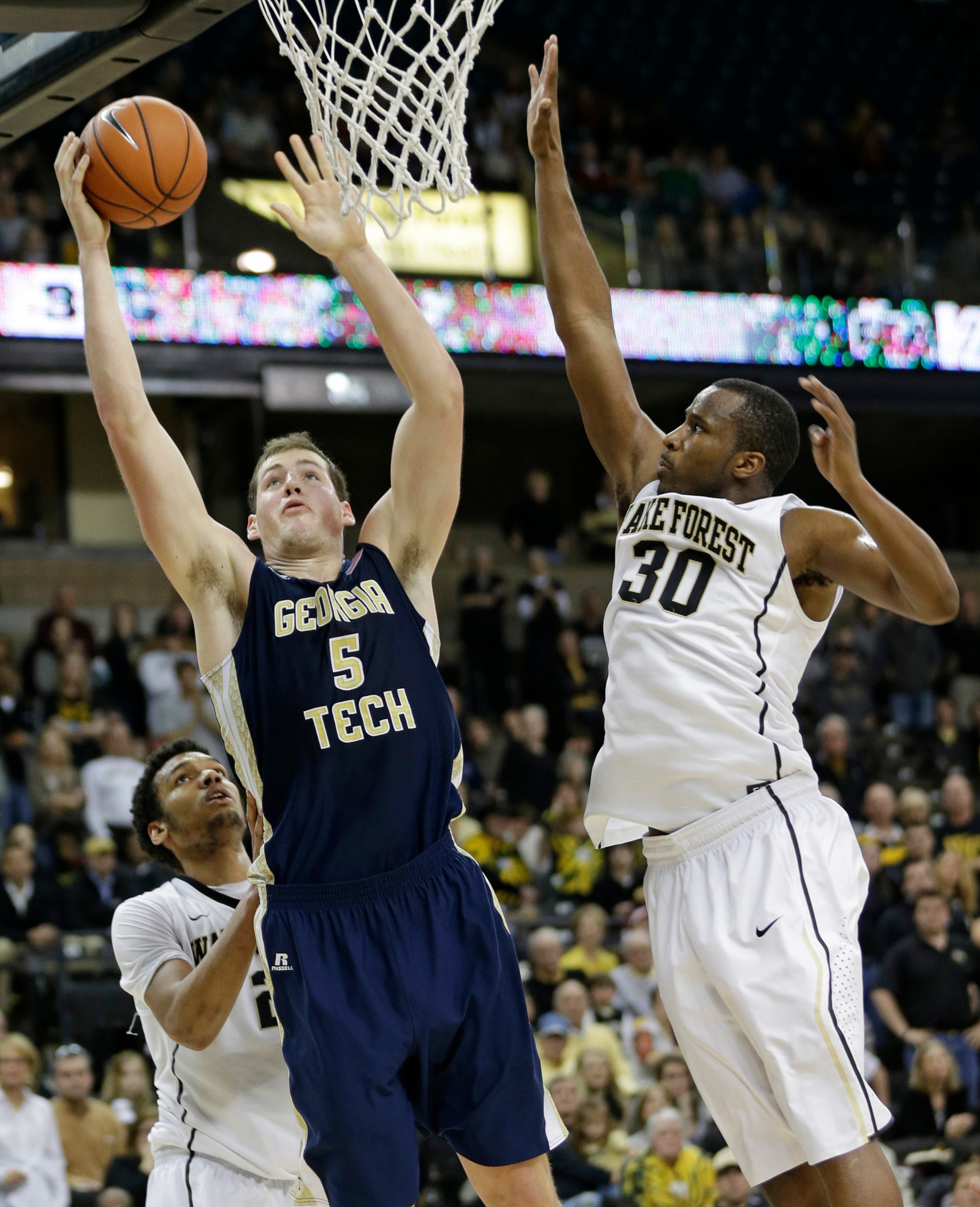Georgia Tech's Daniel Miller (5) drives between Wake Forest's Travis McKie (30) and Devin Thomas (2) during the second half of an NCAA college basketball game in Winston-Salem, N.C., Saturday, Feb. 1, 2014. Georgia Tech won 79-70.