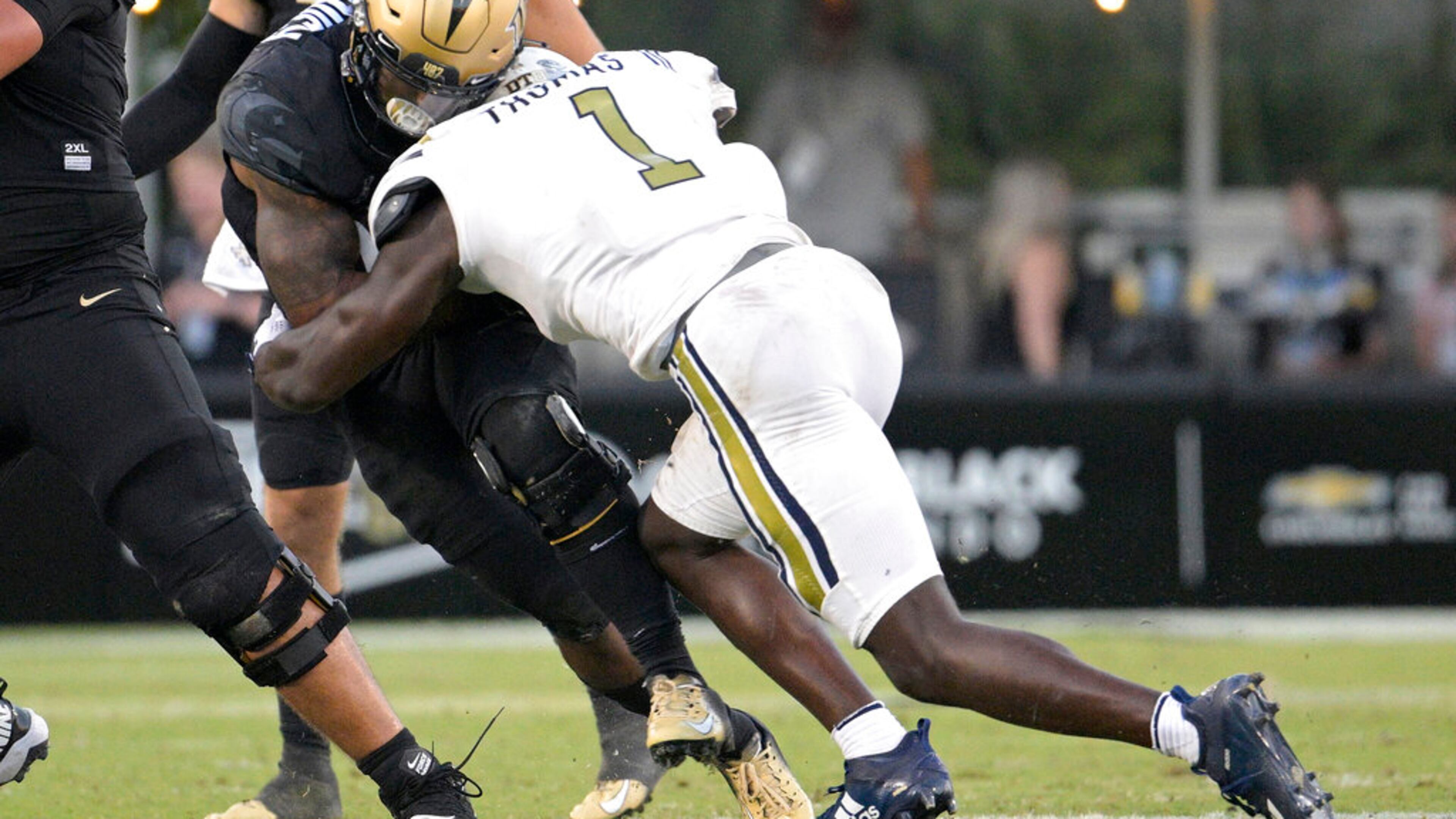 Central Florida running back RJ Harvey, left, is tackled by Georgia Tech linebacker Charlie Thomas (1) after rushing for yardage during the second half of an NCAA college football game, Saturday, Sept. 24, 2022, in Orlando, Fla. Thomas was penalized for targeting on the play and was disqualified from the game. (AP Photo/Phelan M. Ebenhack)
