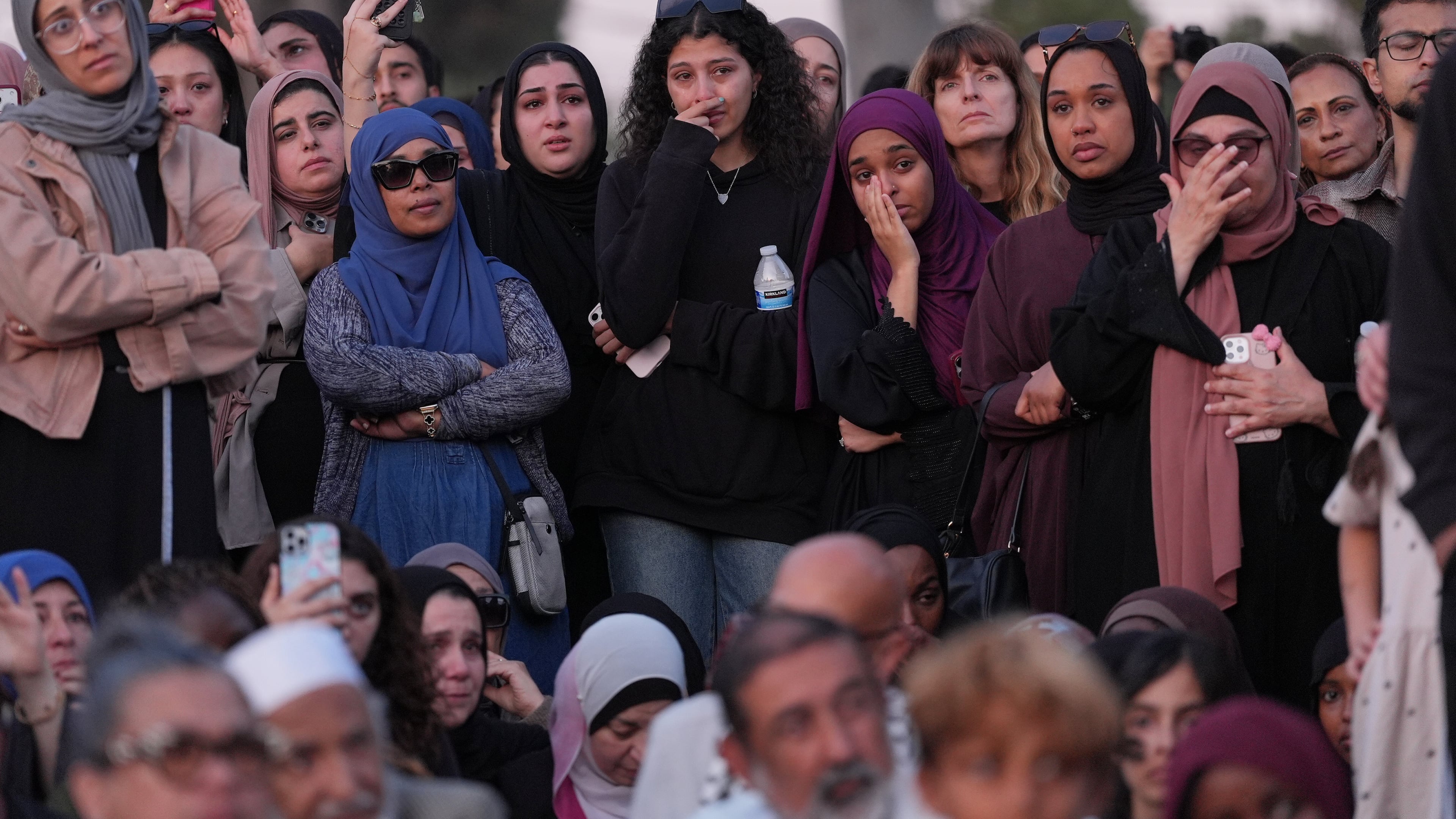Attendees react as they listen to a speech during a vigil, the day after a shooting, outside of the Islamic Center of San Diego, Tuesday, May 19, 2026, in San Diego. (AP Photo/Jae C. Hong)