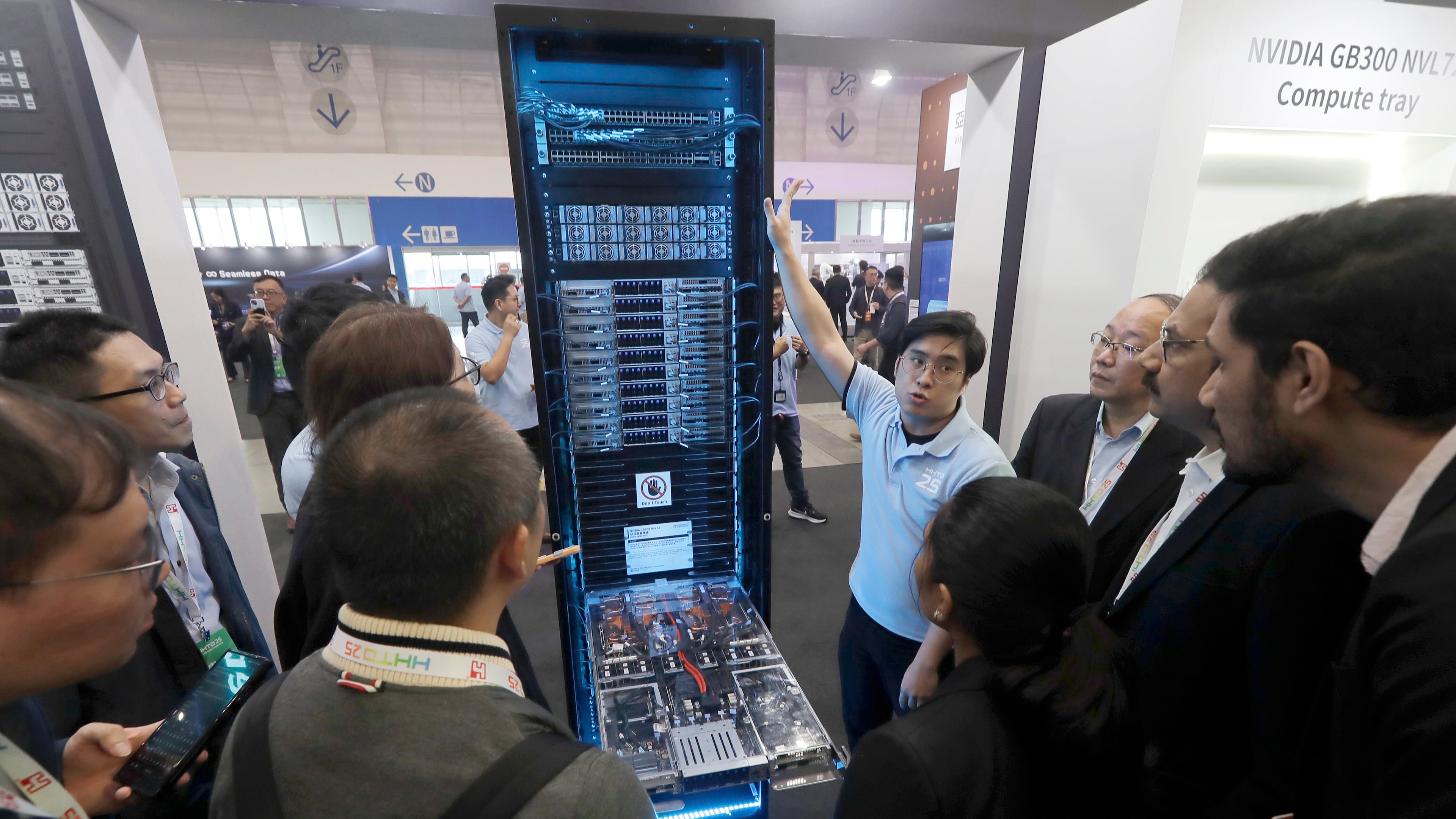 FILE - Visitors listen to the introduction of NVIDIA GB300 NVL72 AI server during the Hon Hai Tech Day (HHTD 25) at the Nangang Exhibition Center in Taipei, Taiwan, Nov. 21, 2025. (AP Photo/Chiang Ying-ying, File)