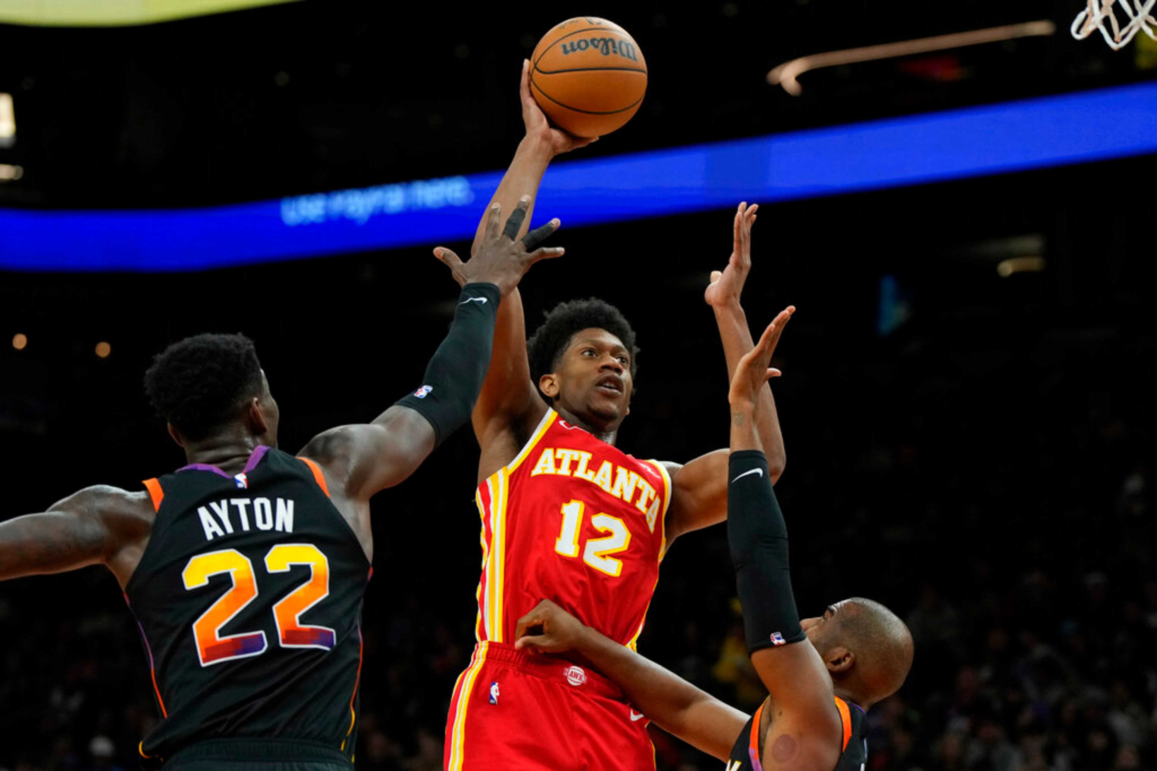 Atlanta Hawks forward De'Andre Hunter shoots over Phoenix Suns center Deandre Ayton (22) and guard Chris Paul during the first half of an NBA basketball game, Wednesday, Feb. 1, 2023, in Phoenix. (AP Photo/Rick Scuteri)