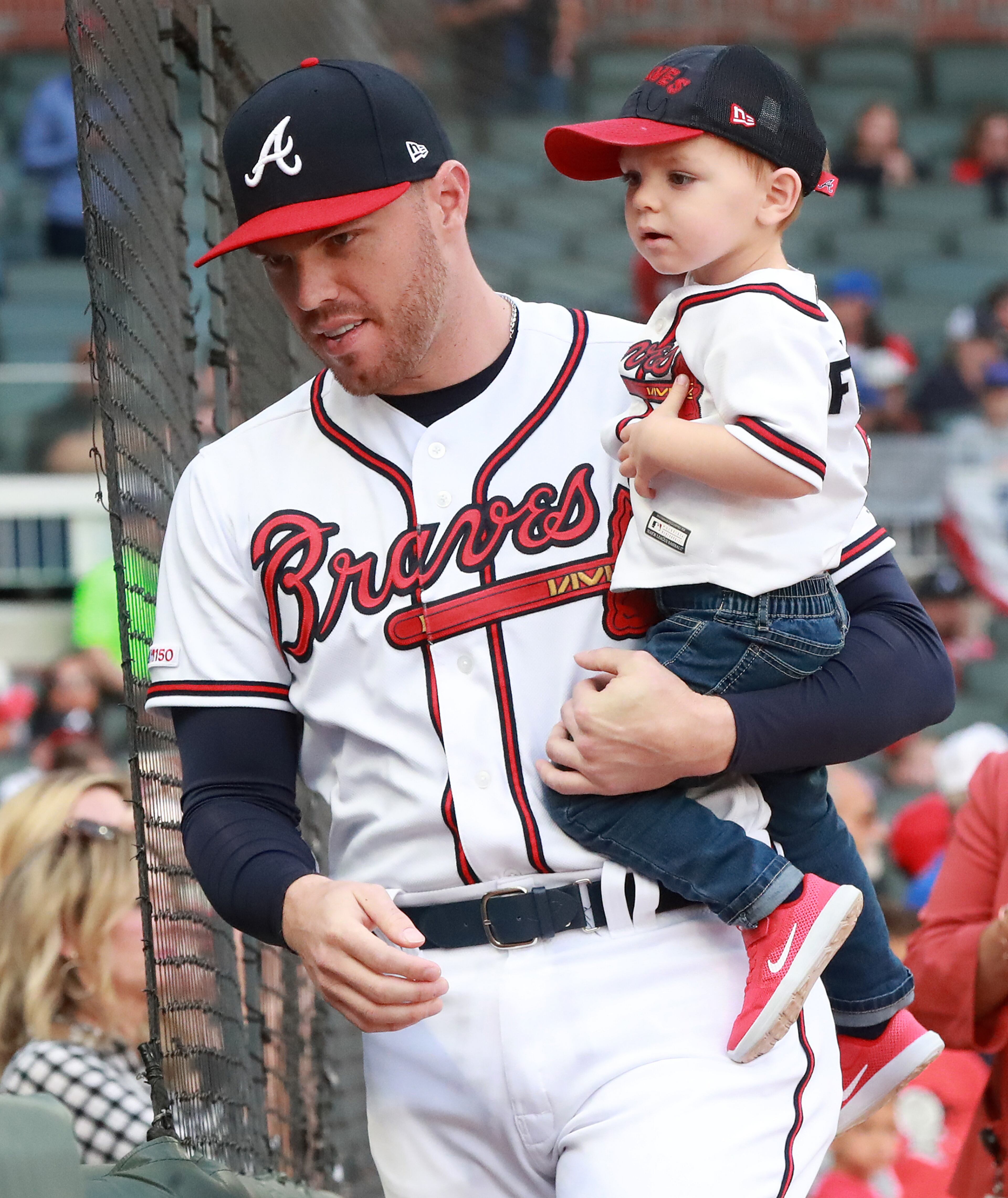 Braves' Freddie Freeman holds his son Charlie during a ceremony presenting the first baseman with the Wilson defensive player of the year and the Rawlings gold glove award. Curtis Compton/ccompton@ajc.com