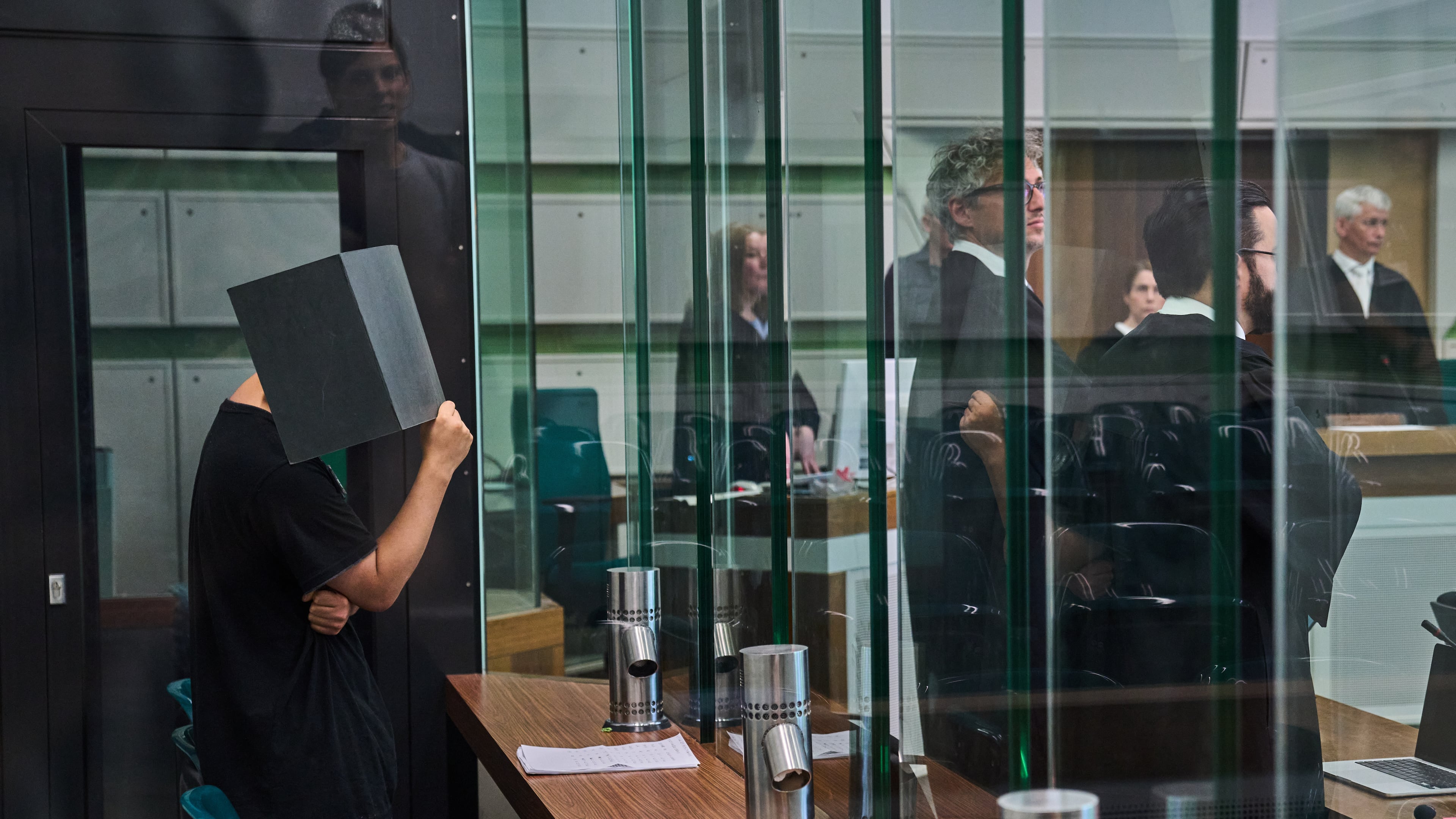 The defendant covering his face in the court during a trial against an online predator network of men accused of using chat groups to share tips on how to drug and rape women, in Berlin, Germany, Wednesday, July 8, 2026. (AP Photo/Ebrahim Noroozi)