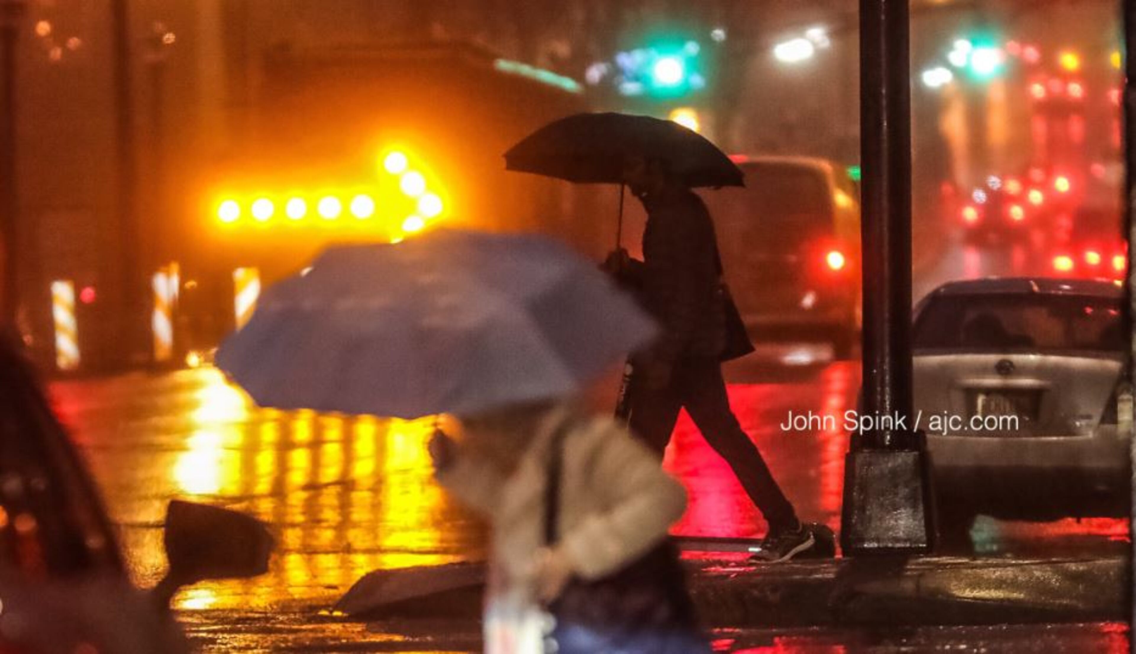 People endure rainy conditions Friday morning at 10th Street and North Avenue.