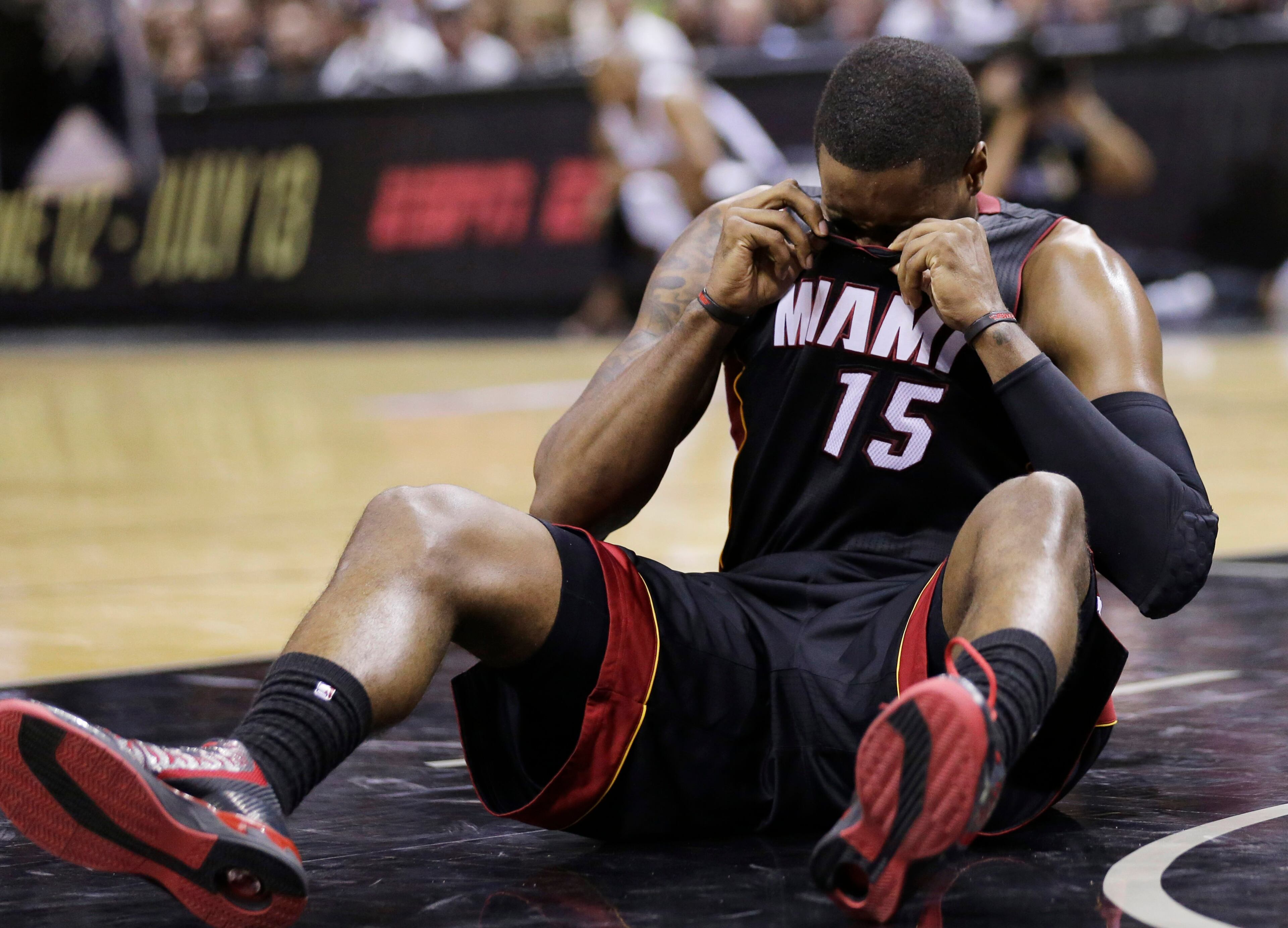 Miami Heat guard Mario Chalmers (15) recovers after hitting the floor against the San Antonio Spurs during the first half in Game 2 of the NBA basketball finals on Sunday, June 8, 2014, in San Antonio. (AP Photo/Eric Gay)