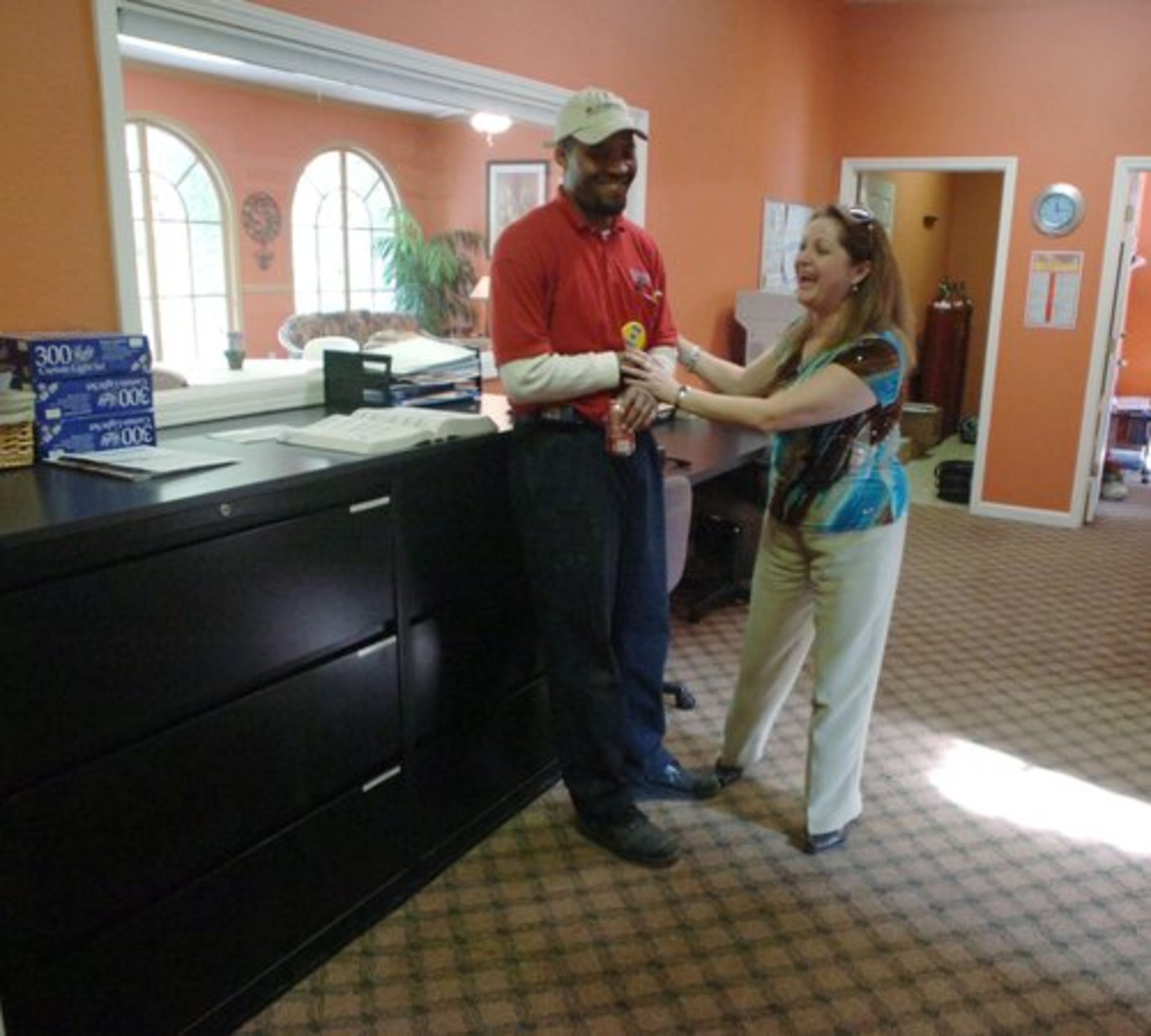 Angela Smith, a native of Colombia, is shown in 2007 at the Las Colinas apartment as she shares a light moment with Las Colinas employee Allen Marrion.