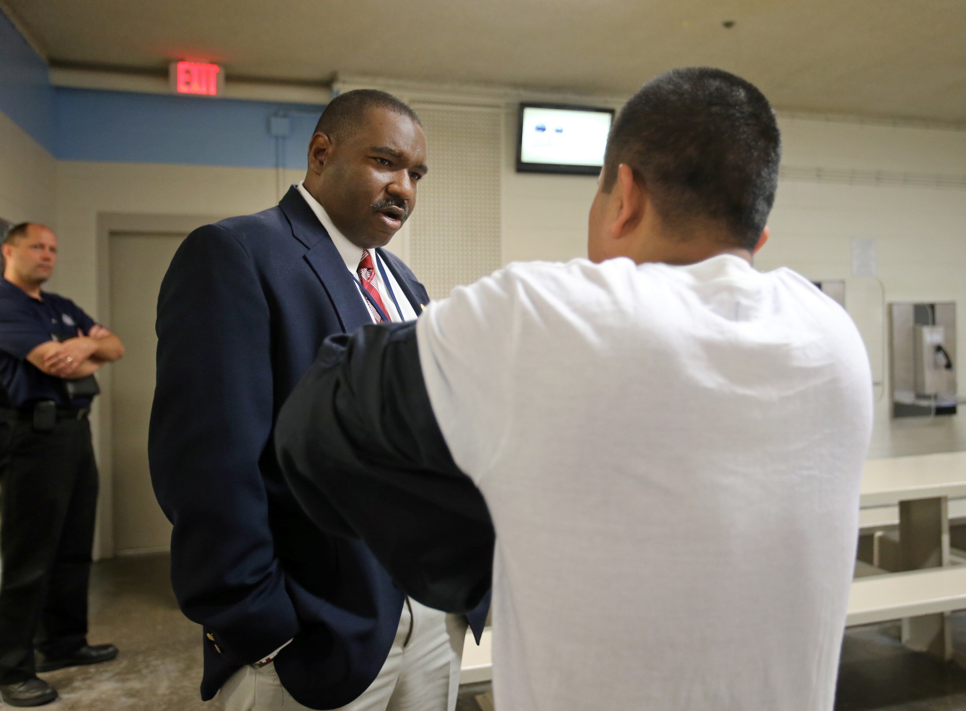 Warden Charlie Peterson, talking with a detainee in the center's open-bay dormitory, says the facility housed an average 378 detainees per day in May.