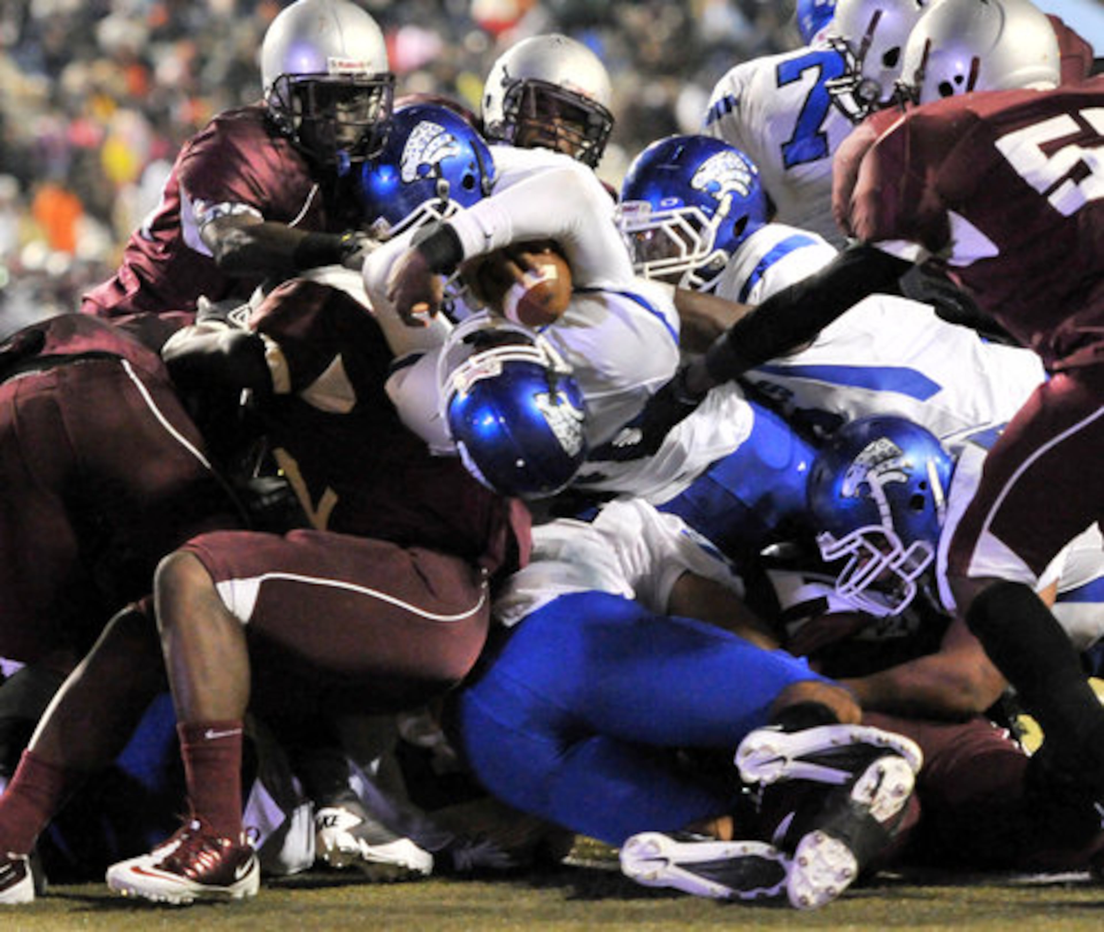 Stephenson Jaguars' Justin Holman (center) pushes through MLK Lions' defense line for a touchdown in the first half at Hallford Stadium Clarkston on Friday, November 4, 2011.