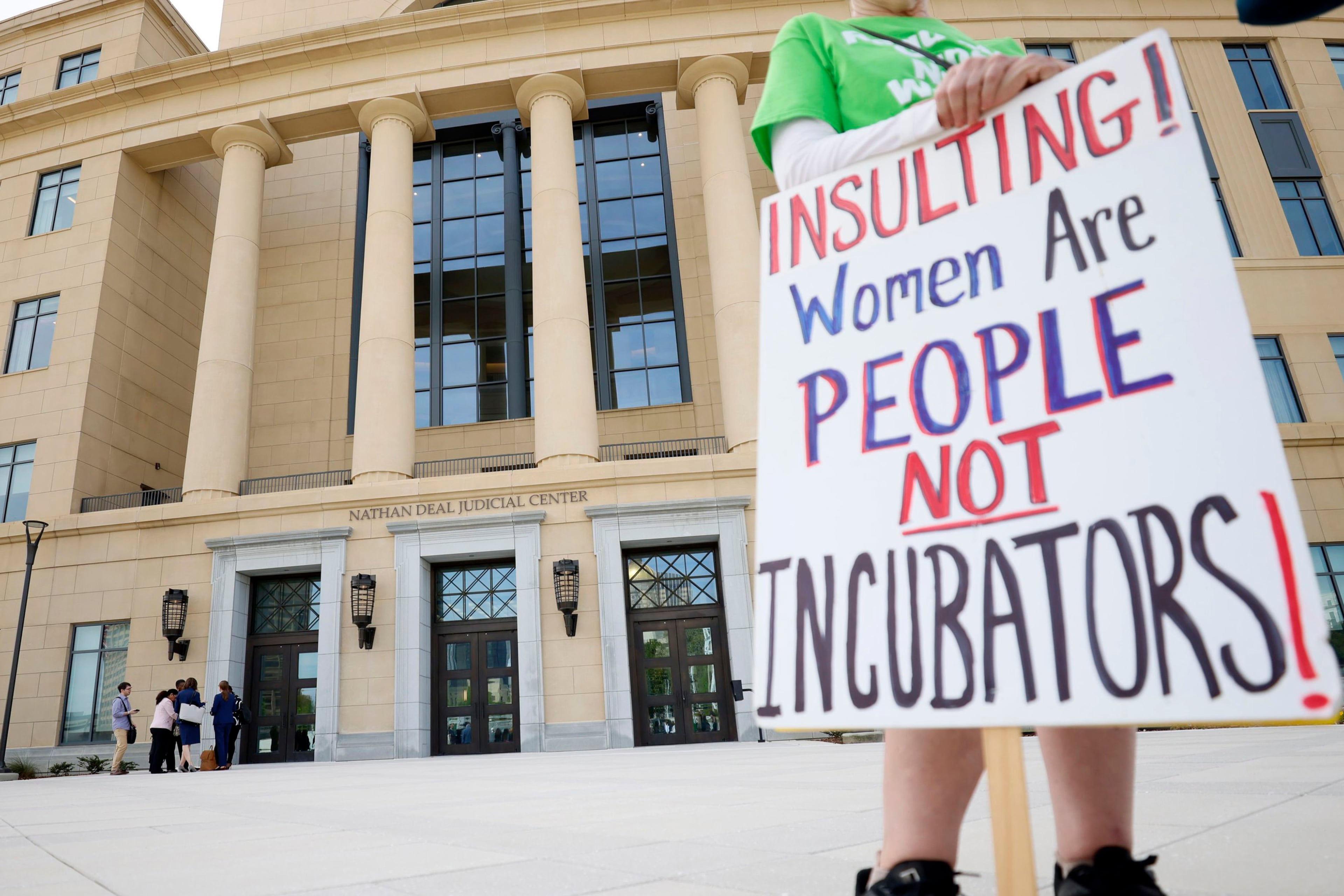 A protester held a sign outside the Nathan Deal Judicial Center during a hearing over the challenge to Georgia's abortion law at the Georgia Supreme Court on March 28, 2023.