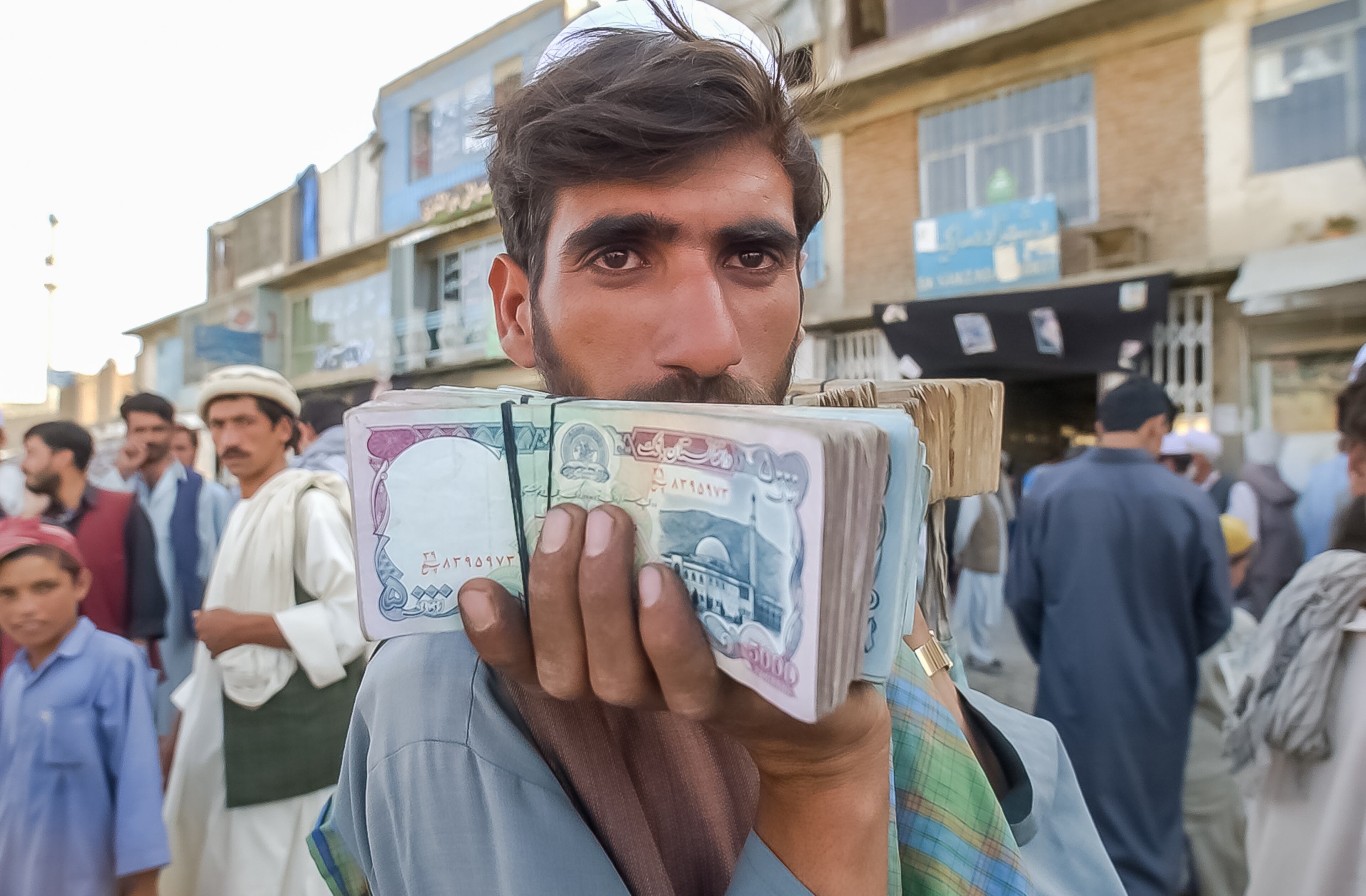 KABUL, AFGHANISTAN: A money changer looks for customers looking to change dollars in Kabul's main bazaar Sunday, Sept. 8, 2002. At the time, one U.S. dollar equaled about 40,000 Afghanis, but the rate fluctuated greatly day-to-day. (Bita Honarvar / The Atlanta Journal-Constitution)