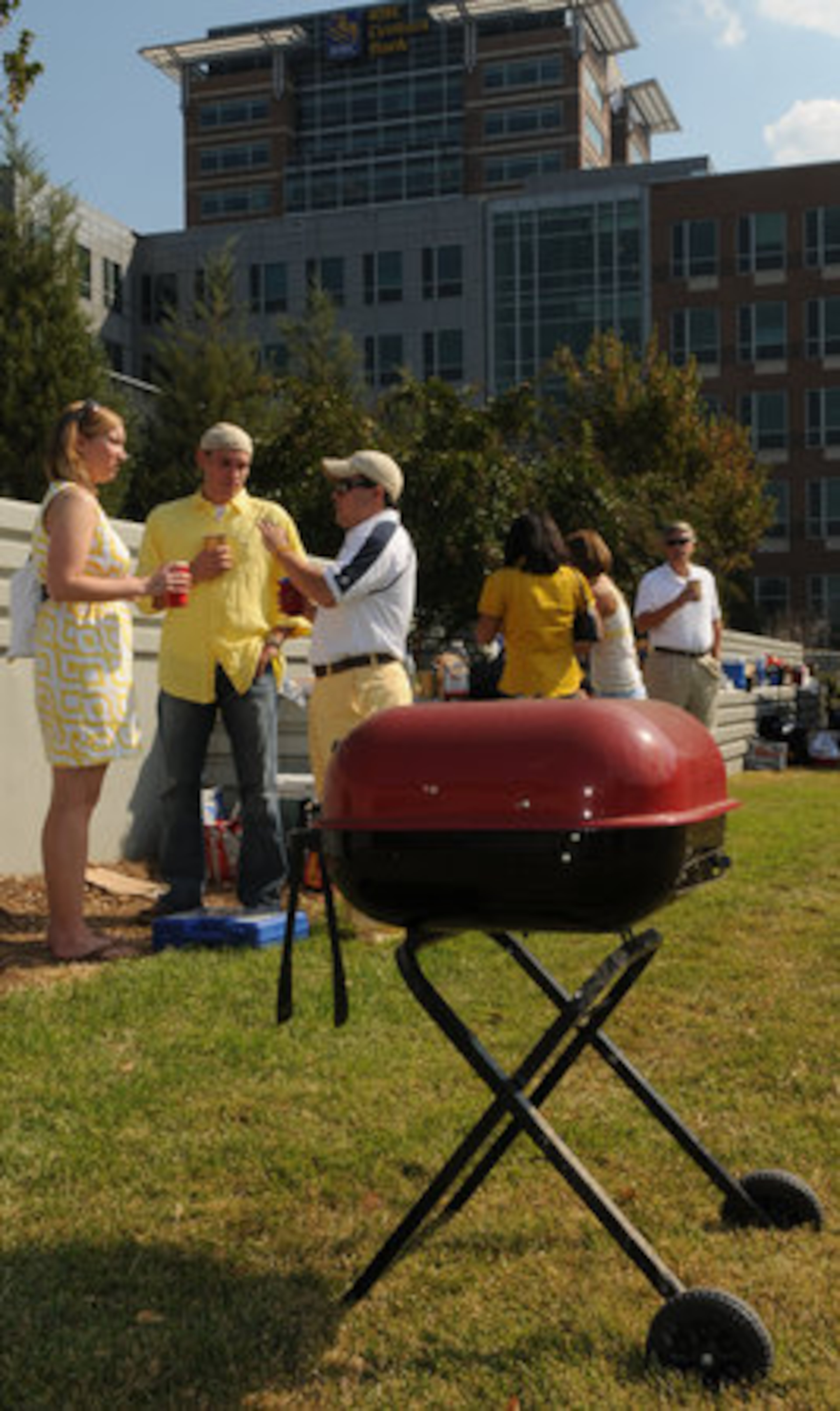 Georgia Tech alumnus Adair Schwartz (left) and Nick Rossi(right) chat with former Tech basketball player Matt Causey (center) near Matt's red grill.