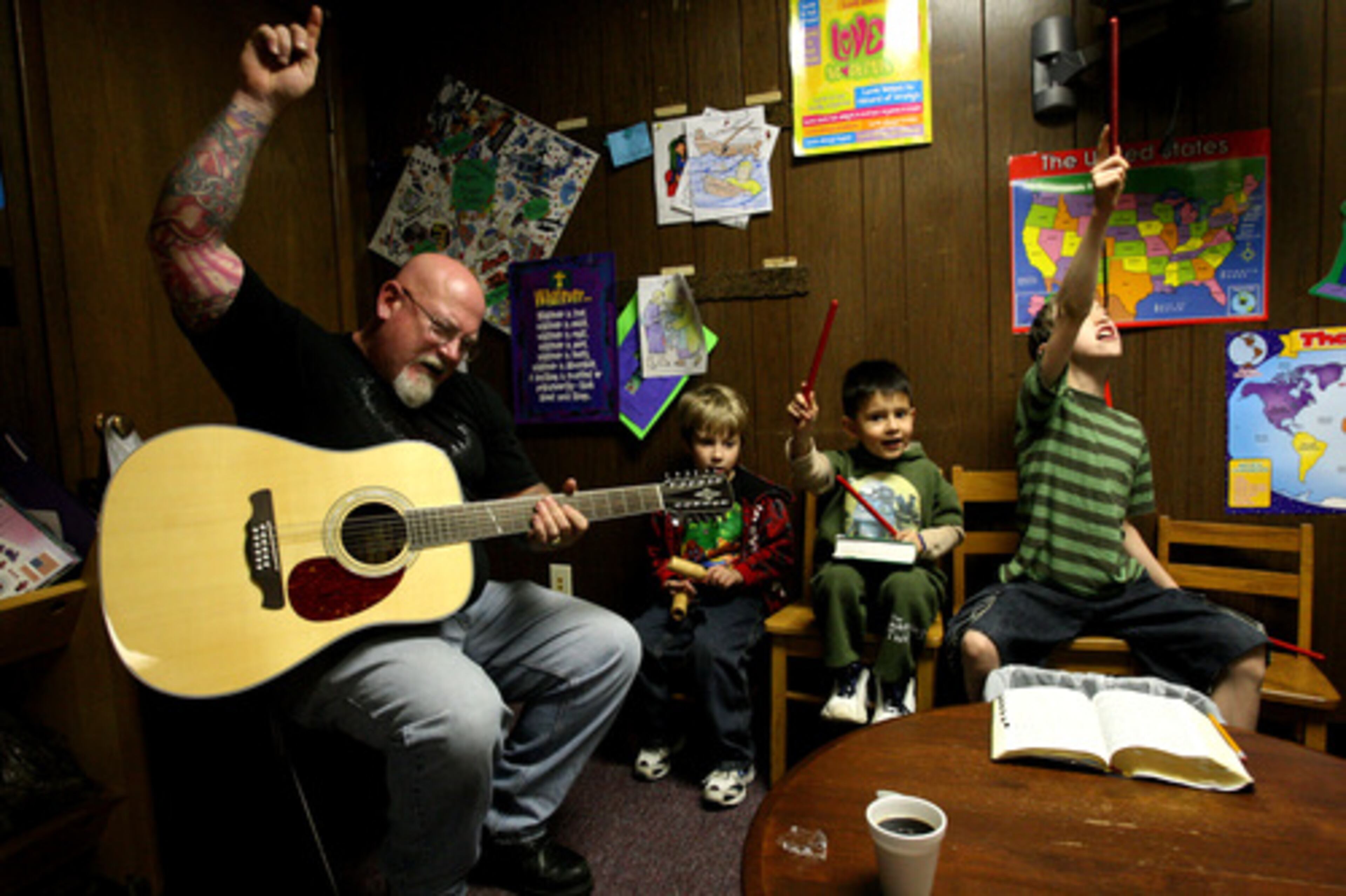 Tom Hamilton, 51, co-pastor of Sozo New Covenant Fellowship Church in Tucker and a U.S. Naval Academy grad, plays the guitar as his students (left to right) Chance Miller, Ralphie Kilelee, and Brandon Reda play instruments
