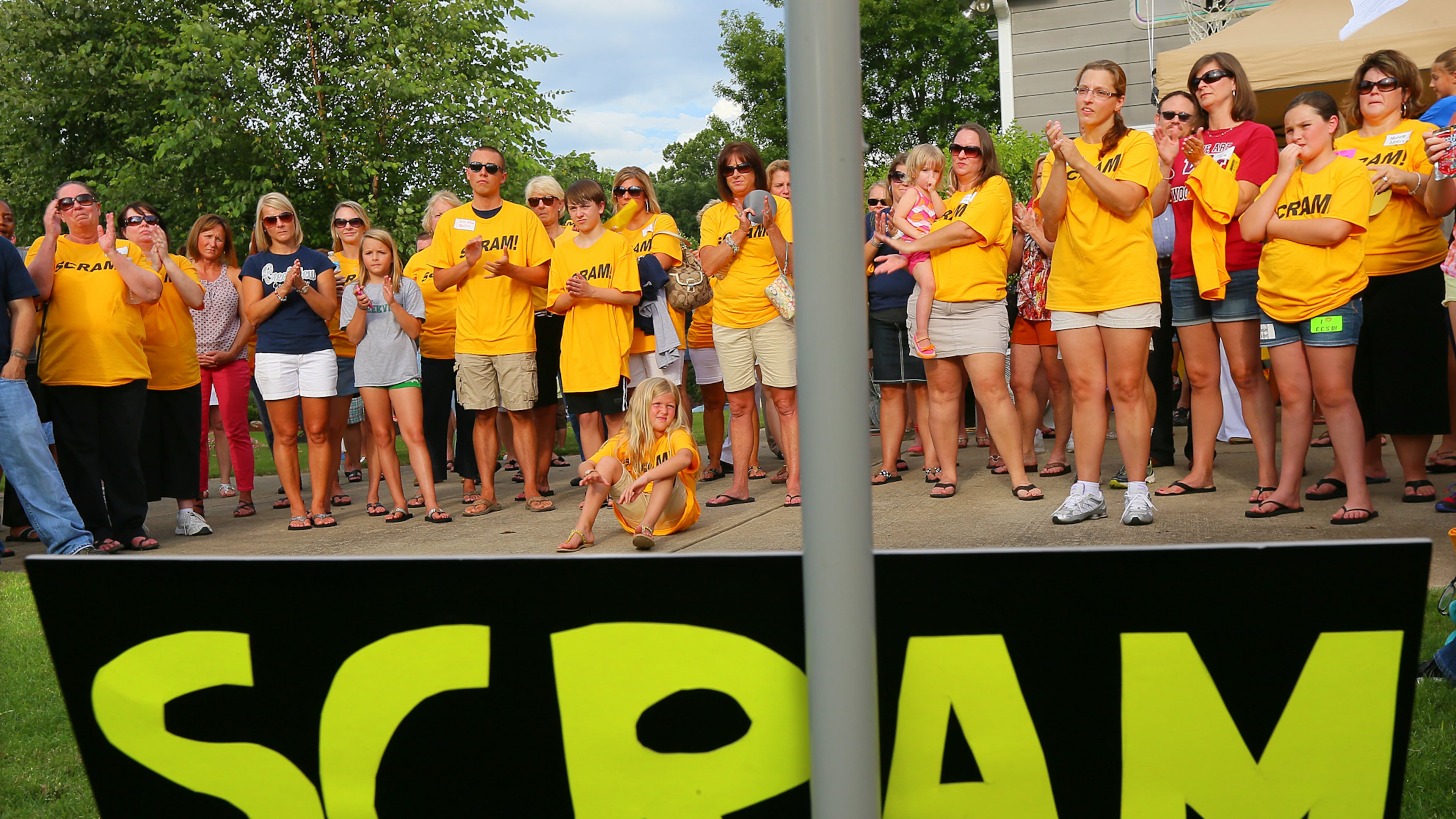 About 100 members of SCRAM (Smart Citizens Rally Against Marlow) hold a rally to oust Cherokee School Board member Kelly Marlow in Bridge Mill Subdivision on July 8, 2013, in Canton. Marlow, her political adviser Robert John Trim and secretary of the local Republican Party Barbara Knowles were arrested over the weekend. They have been charged with filing a false police report after they accused the school superintendent of trying to hit them with his car.
