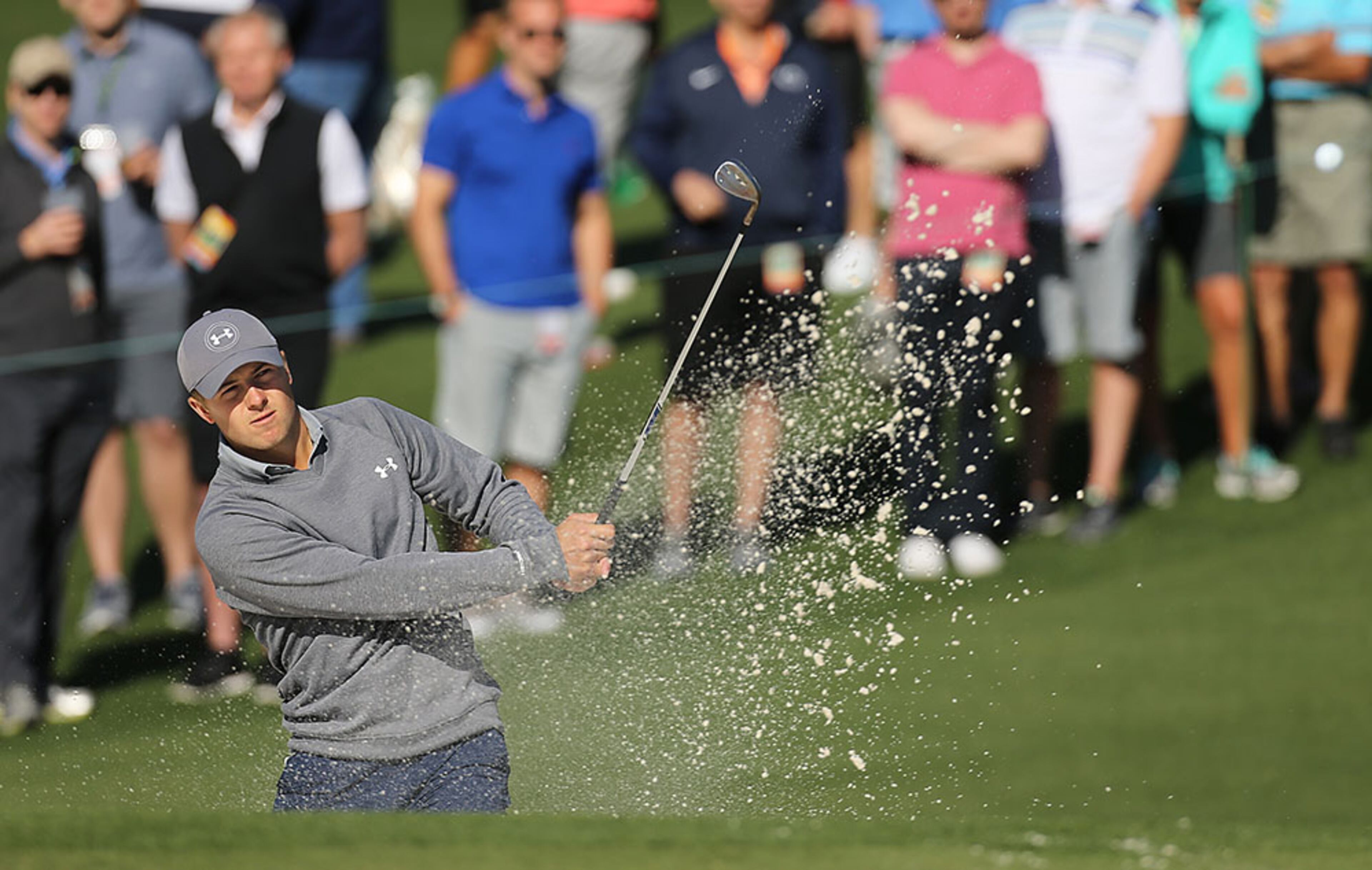The gallery watches as Masters defending champion Jordan Spieth hit his sand shot to the second green during his practice round at Augusta National Golf Club on Tuesday, April 5, 2016, in Augusta.