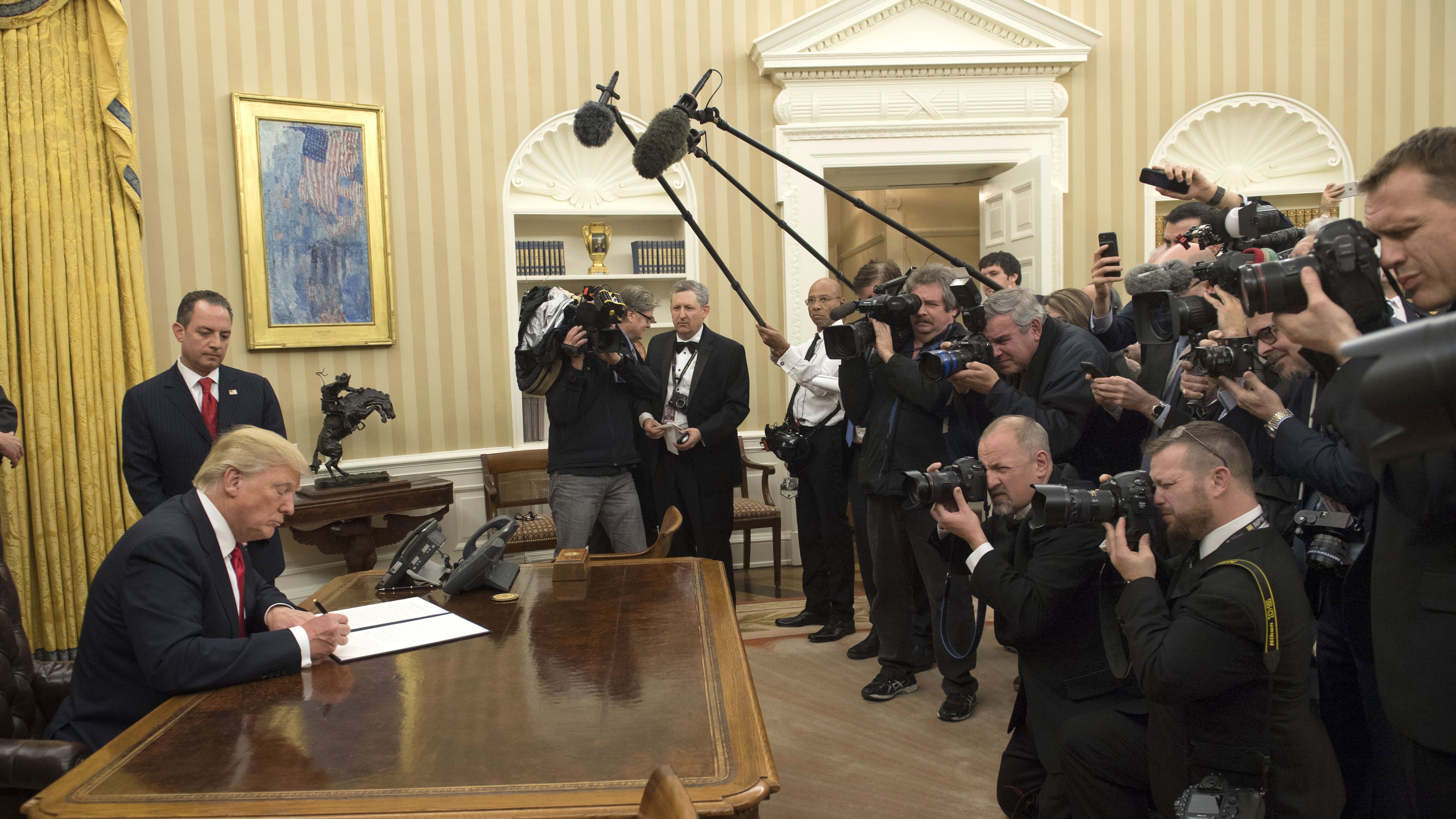 President Donald Trump signs his first executive order as president, ordering federal agencies to ease the burden of President Barack Obama's Affordable Care Act January 20, 2017 in Washington, DC. (Photo by Kevin Dietsch - Pool/Getty Images)