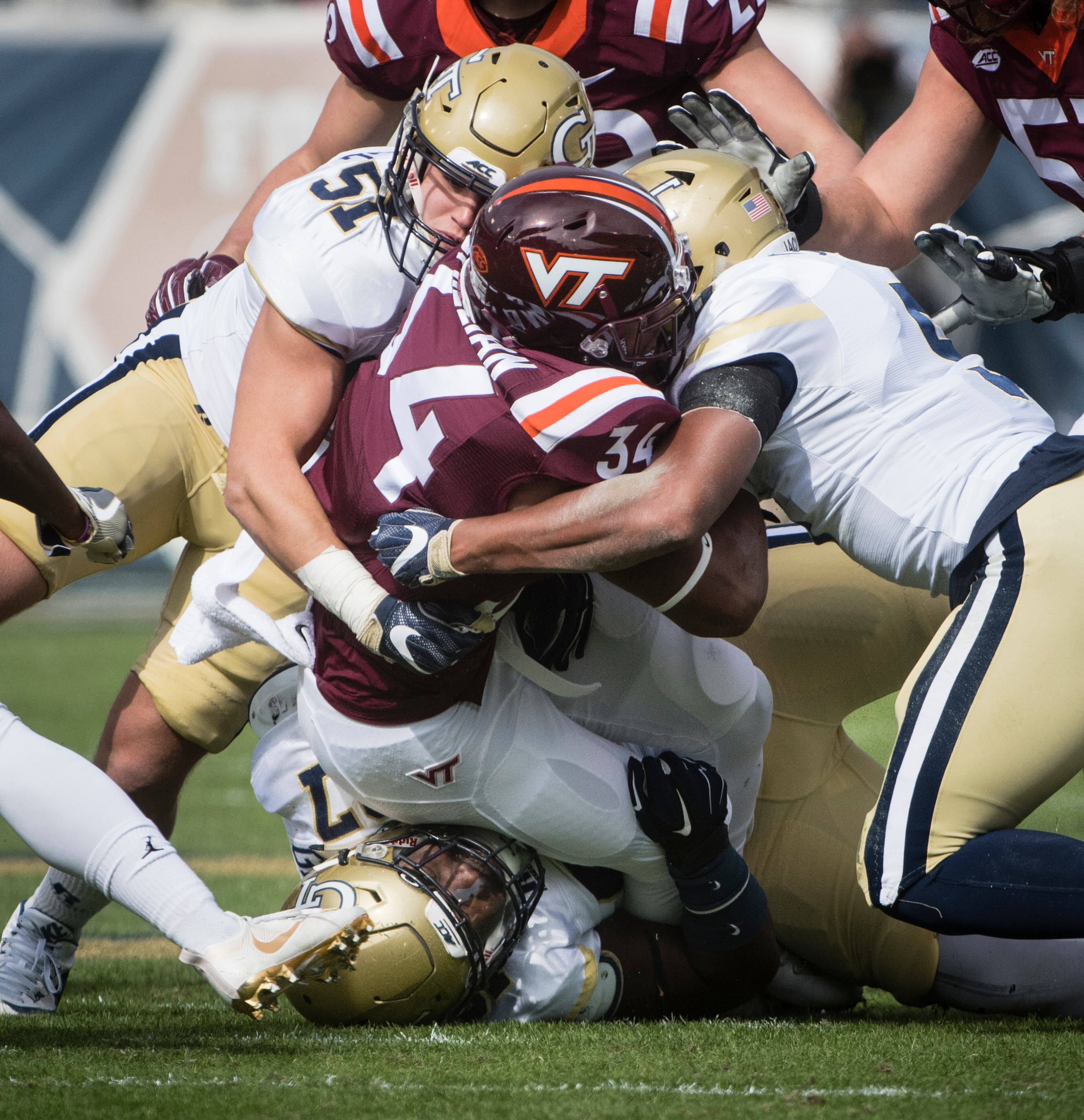 Georgia Tech linebacker Brant Mitchell (51) and defensive back A.J. Gray (5) tackle Virginia Tech running back Travon McMillian (34) during the first half of a football game on Saturday, Nov.11, 2017, in Atlanta. (Photo/John Amis)