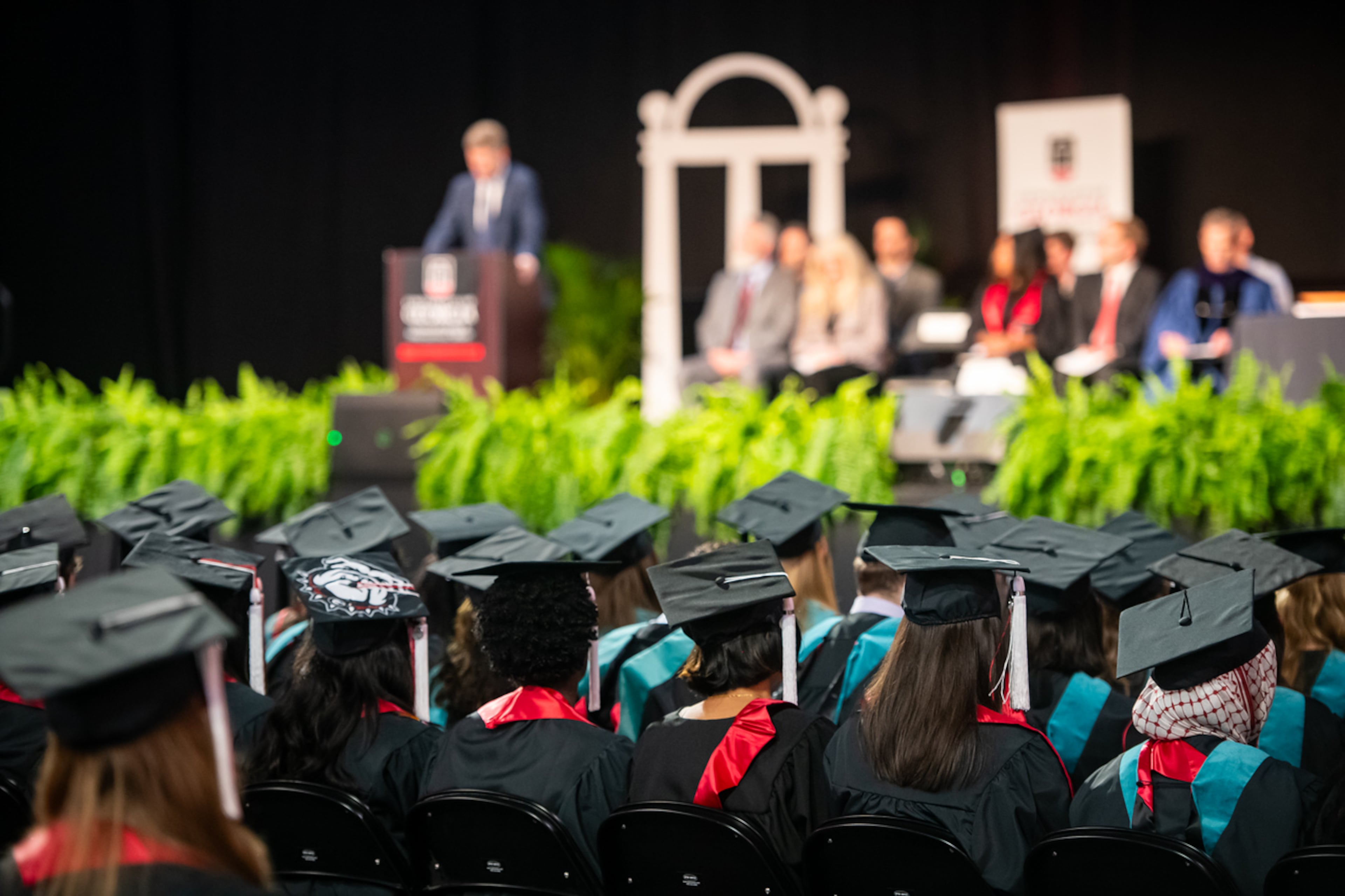Graduates watch as AJC chief political reporter Greg Bluestein delivers the convocation address at the University of Georgia's School of Public and International Affairs on May 8, 2026. (Justin Evans for the AJC)