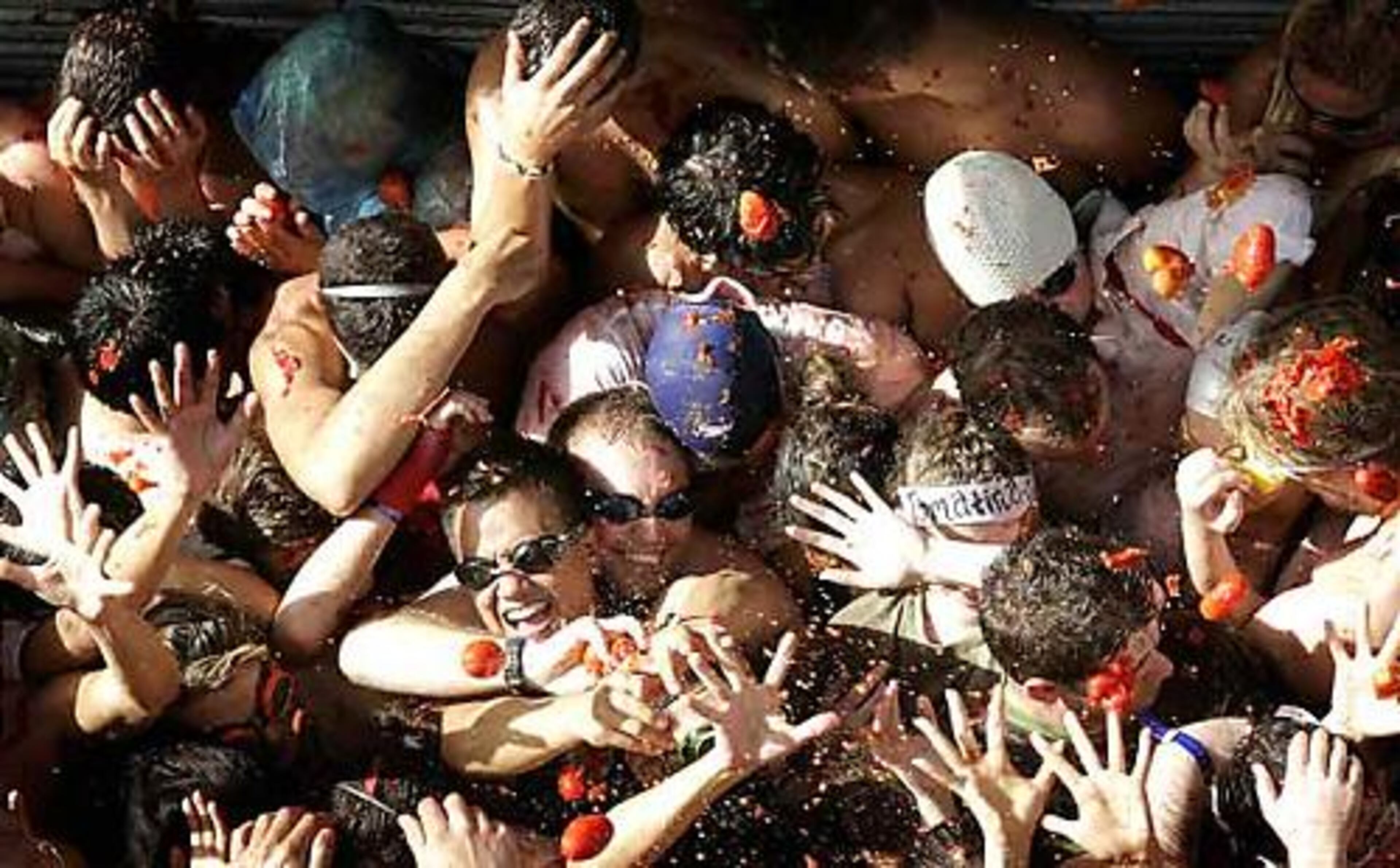 Revelers throw tomatoes at each other during the Tomatina on Wednesday. Each year, tens of thousands of people hurl truckloads of tomatoes at each other, sending knee-deep rivers through the town.