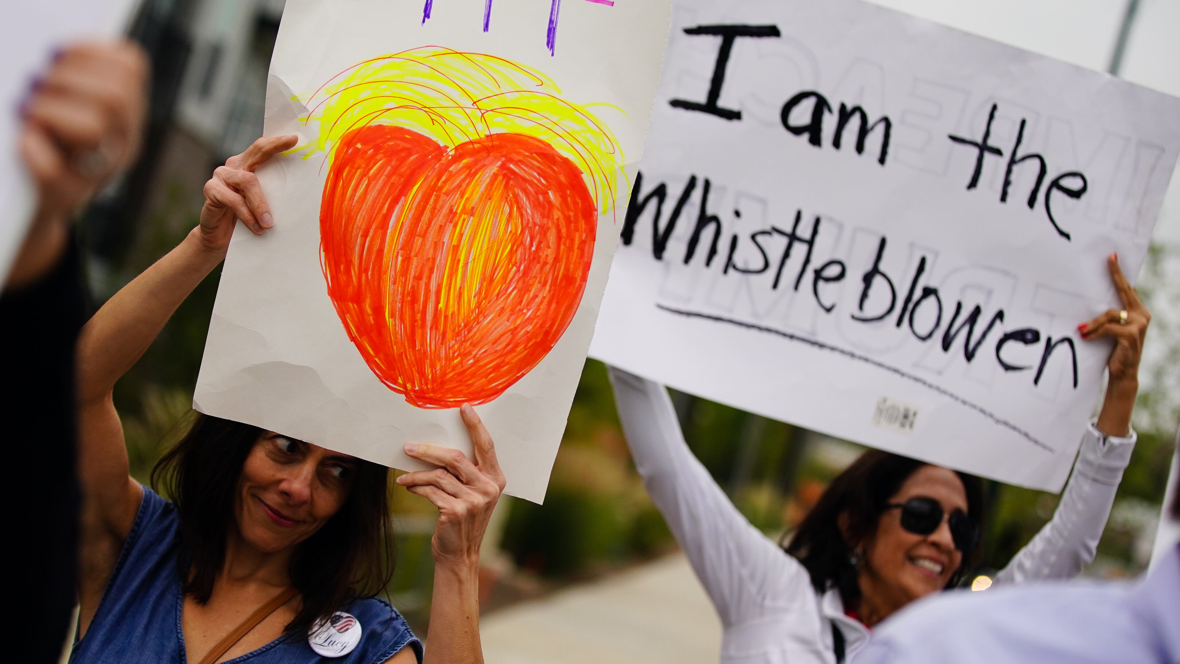 People hold signs supporting Rep. Lucy McBath and the impeachment of President Trump outside the Rep. Mcbath's office on Wednesday, October 9, 2019, in Sandy Springs. (Elijah Nouvelage for The Atlanta Journal-Constitution)