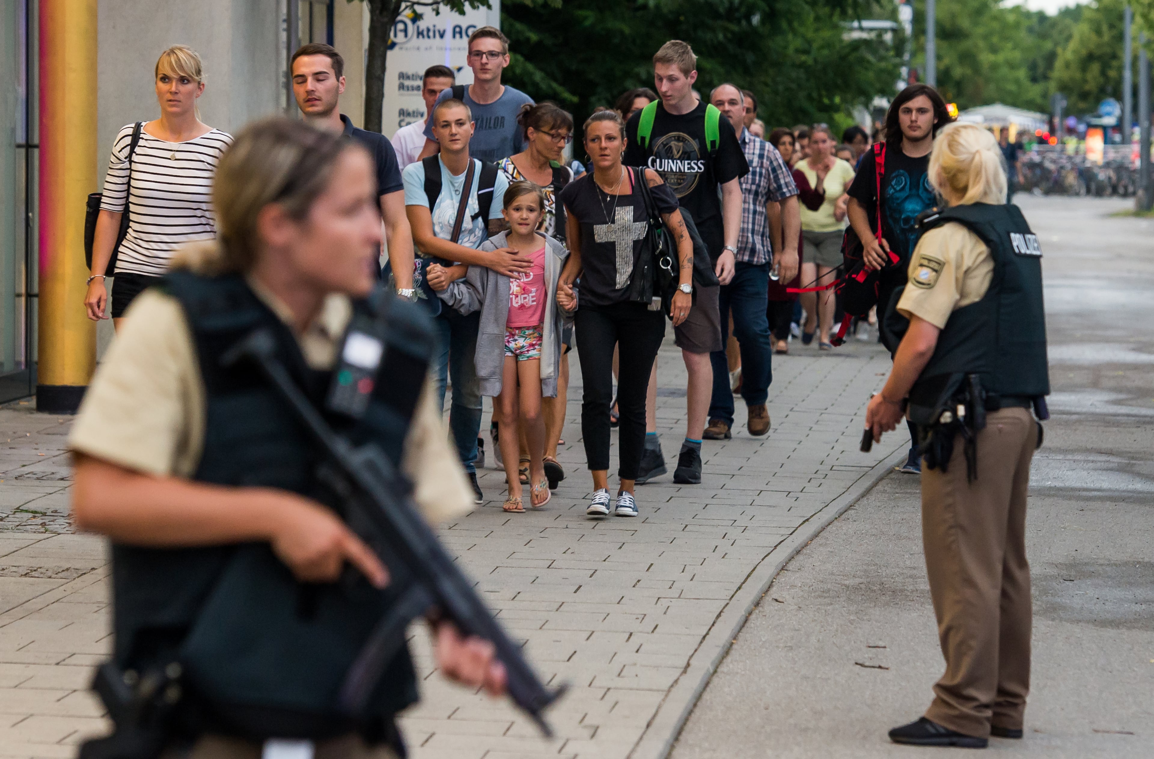 Police officers escort people from inside the shopping center as they respond to a shooting at the Olympia Einkaufzentrum (OEZ) at July 22, 2016 in Munich, Germany. According to reports, several people have been killed and an unknown number injured in a shooting at a shopping centre in the north-western Moosach district in Munich. Police are hunting the attacker or attackers who are thought to be still at large. (Photo by Joerg Koch/Getty Images)