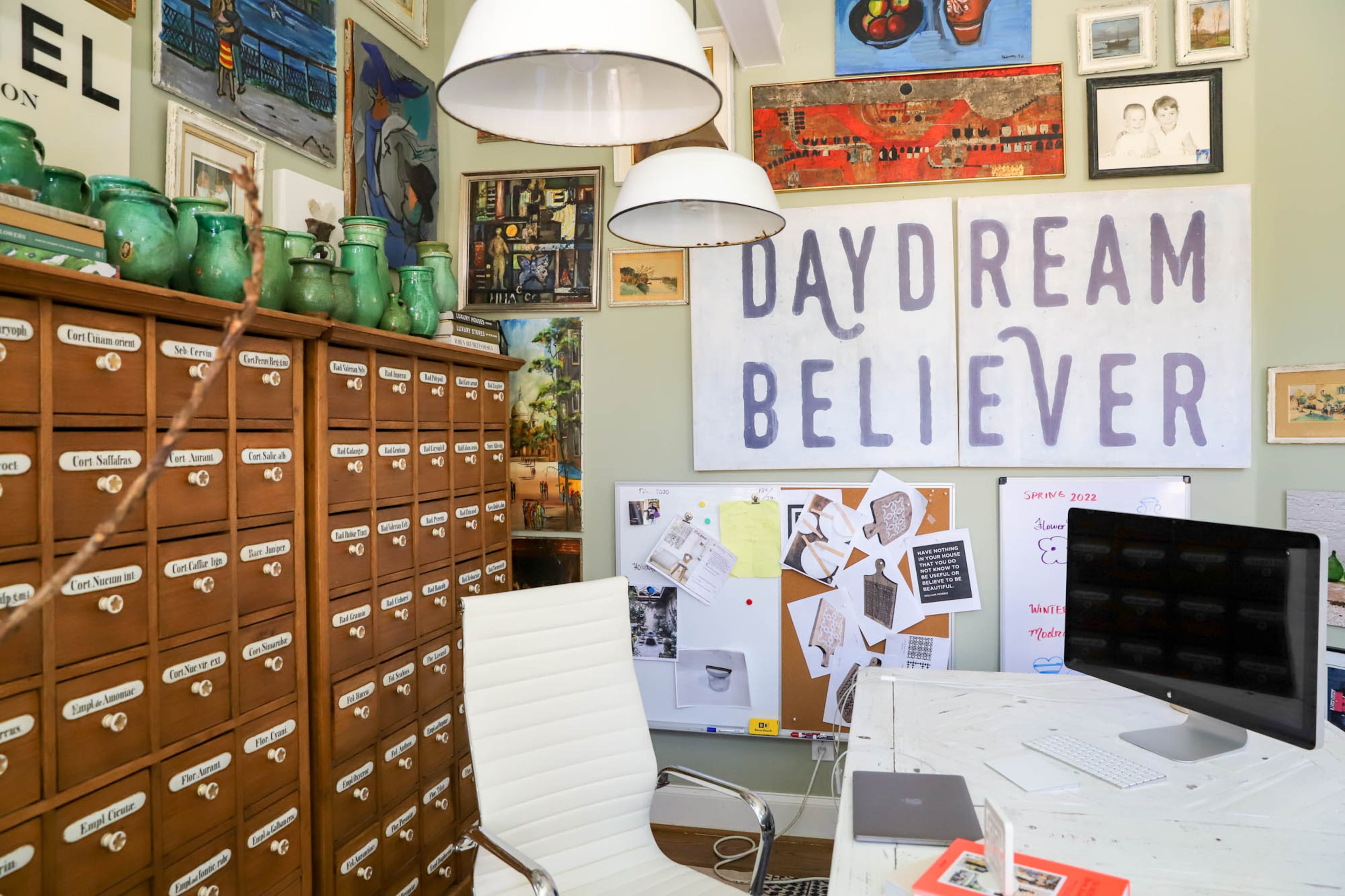 In Stacy Borocz’s study, she has oak units from a 19th-century Hungarian pharmacy. Porcelain labels and knobs adorn the outside, and on the underside of the drawers are signatures from pharmacy apprentices, the oldest of which is from 1817. On top of these units sit Stacy’s collection of Hungarian green pottery, and on the wall hangs art with the words “daydream believer” from Stacy’s friend Rebecca Puig, the artist behind Sugarboo & Co. Text by Shannon Dominy/Photo by Reynolds Rogers