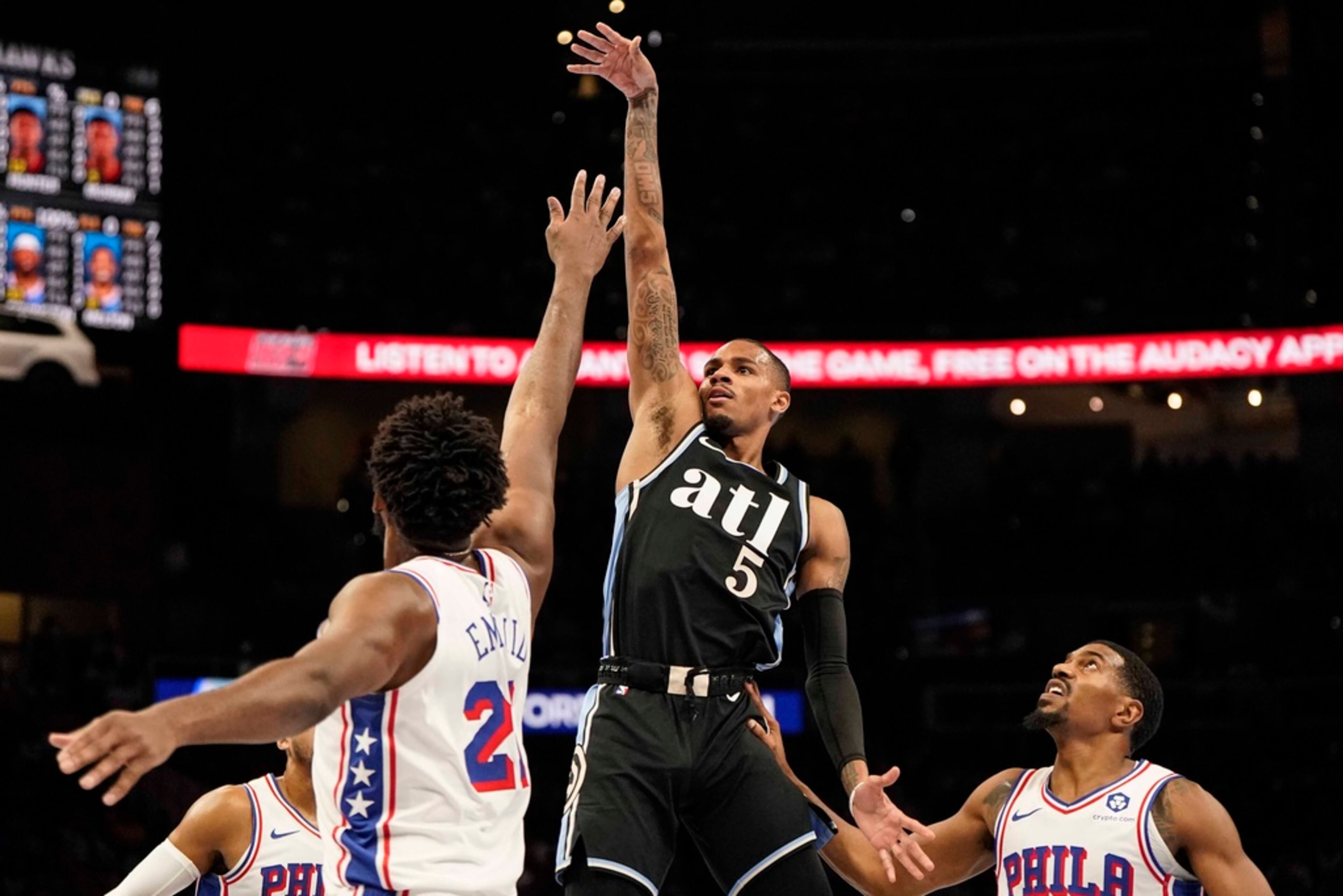 Atlanta Hawks guard Dejounte Murray (5) shoots against Philadelphia 76ers center Joel Embiid (21) during the first half of an In-Season Tournament NBA basketball game, Friday, Nov. 17, 2023, in Atlanta. (AP Photo/Mike Stewart)
