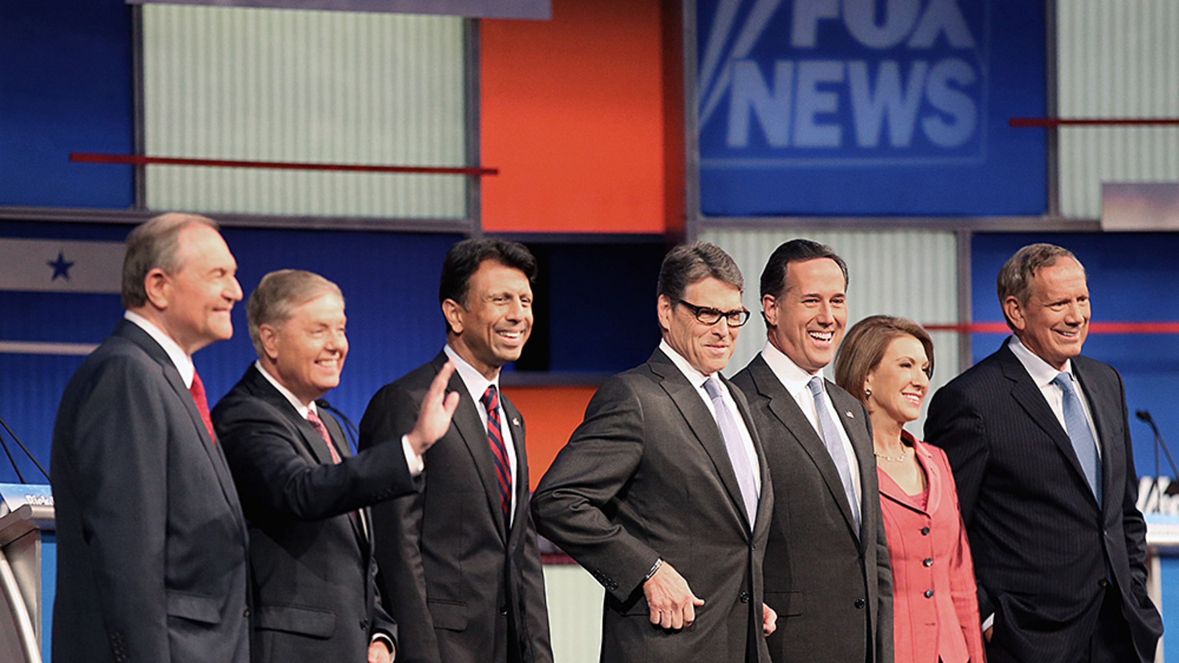 CLEVELAND, OH - AUGUST 06: Republican presidential candidates (L-R) Jim Gilmore, Sen. Lindsey Graham (R-SC), Louisiana Gov. Bobby Jindal, Rick Perry, Rick Santorum, Carly Fiorina and George Pataki pose for photographs at the beginning of a presidential forum hosted by FOX News and Facebook at the Quicken Loans Arena August 6, 2015 in Cleveland, Ohio. The seven GOP candidates were selected to participate in the forum based on their rank in an average of the five most recent national political polls. (Photo by Scott Olson/Getty Images)