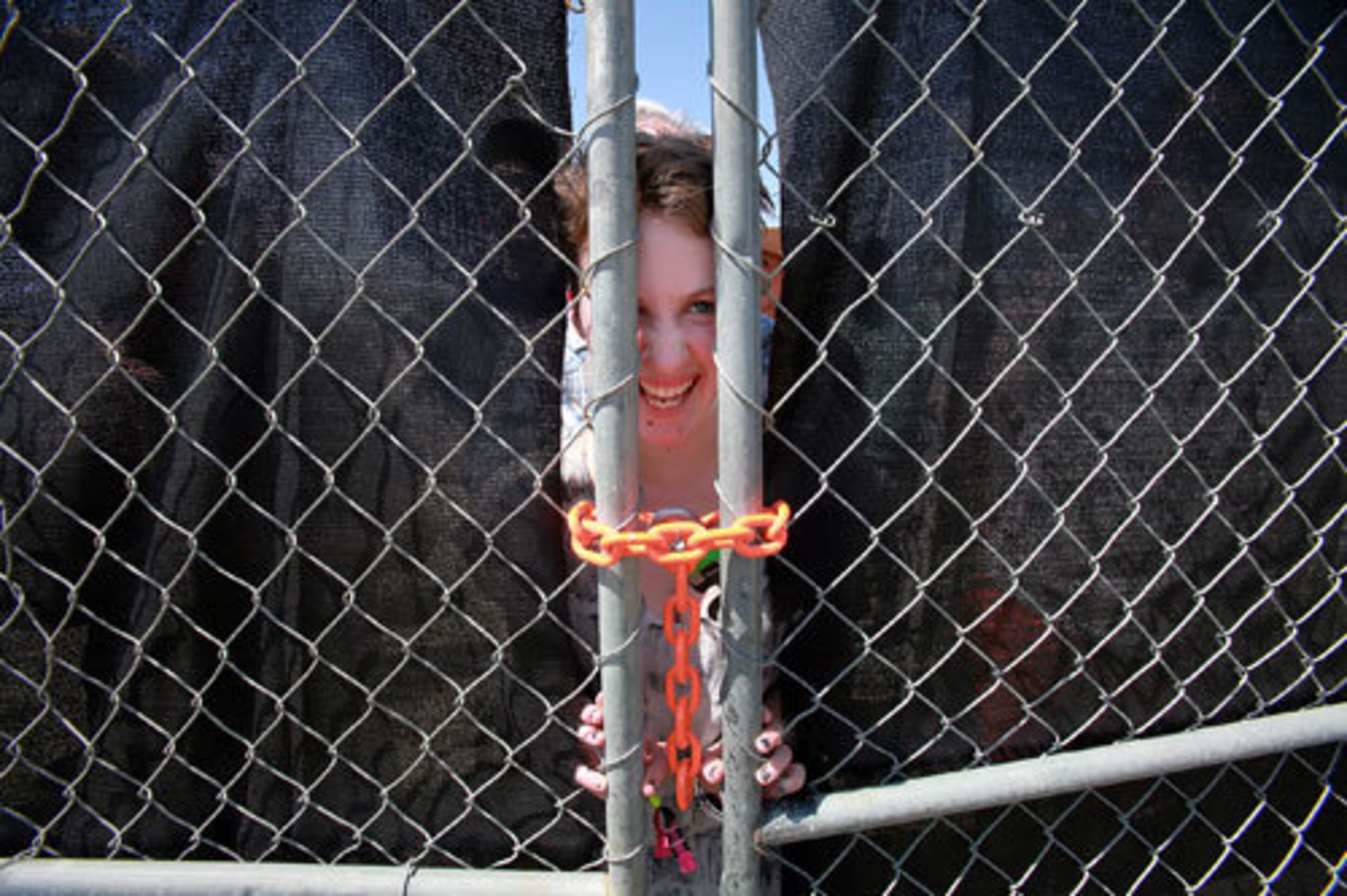 Cheyenne Sykes, 18, of Vancouver, Canada, waits behind a locked gate for the opening of the 12th Coachella Valley Music and Arts Festival.