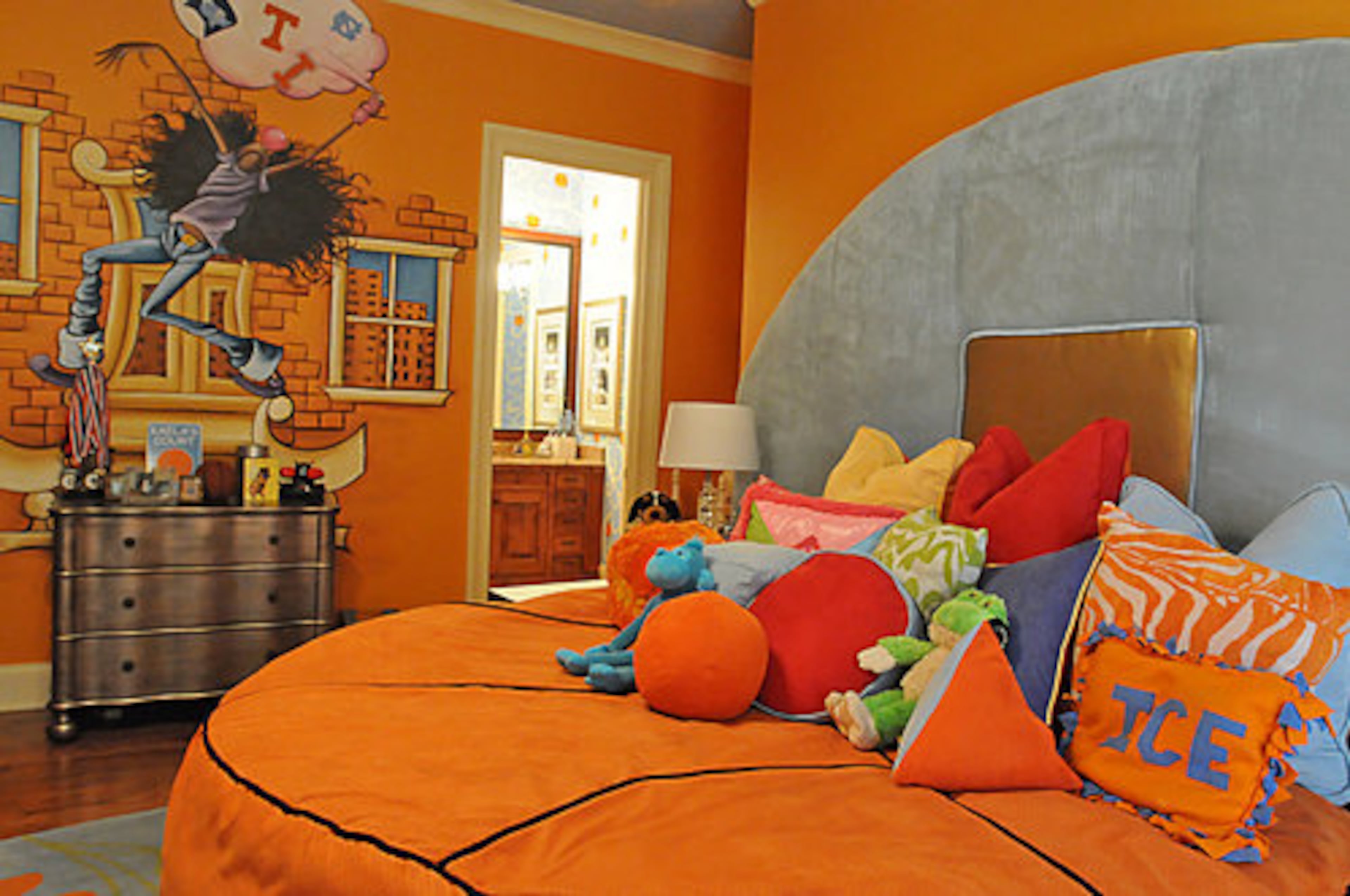 Both of the children's rooms have basketball themes. Daughter Kaela's room features a lively color scheme and a basketball-shaped bed with original artwork on the wall above the dresser.