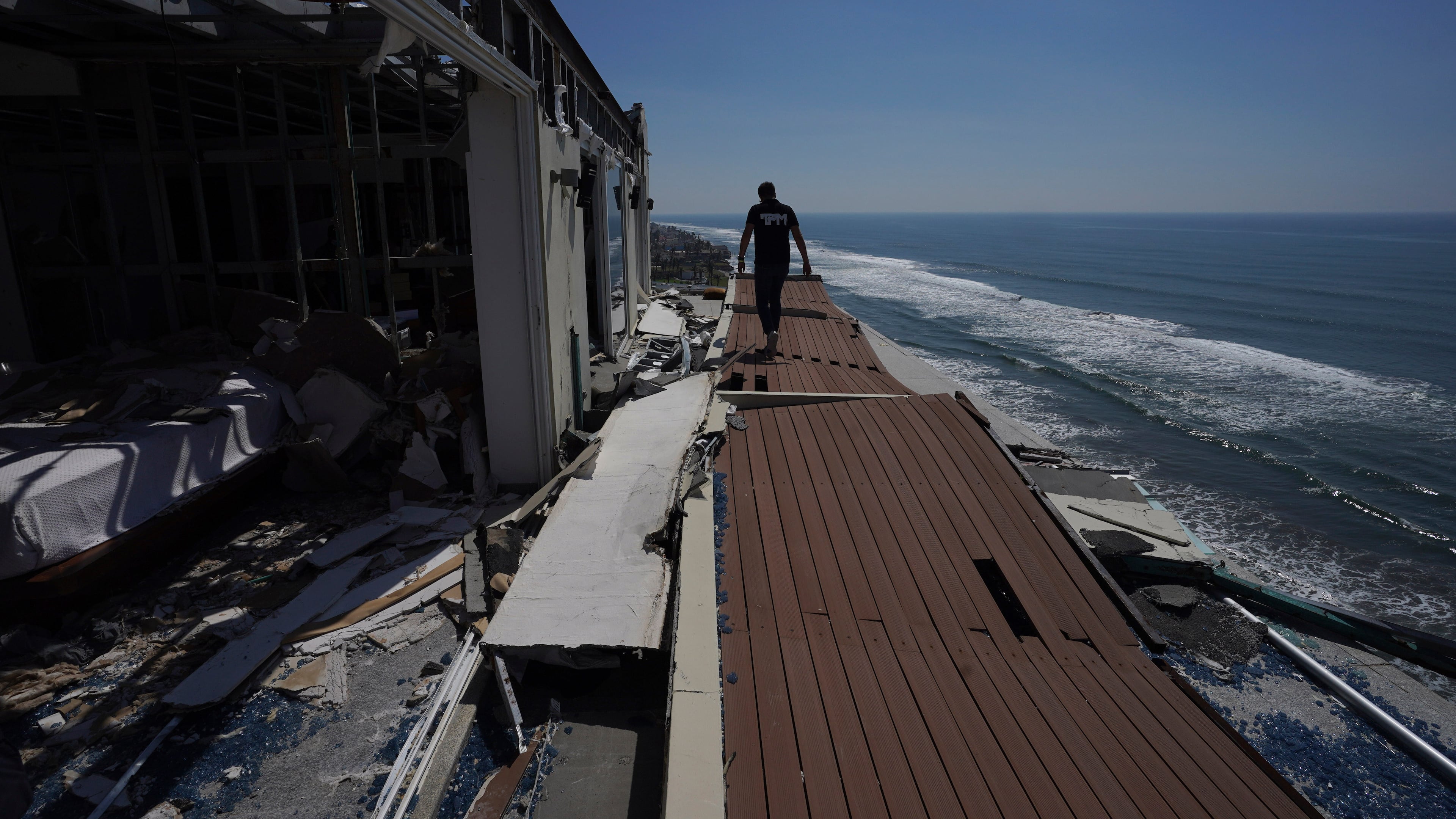 FILE - A man walks alongside damaged apartments in the aftermath of Hurricane Otis, in the Diamonds subdivision of Acapulco, Mexico, Nov. 9, 2023. (AP Photo/Marco Ugarte, File)