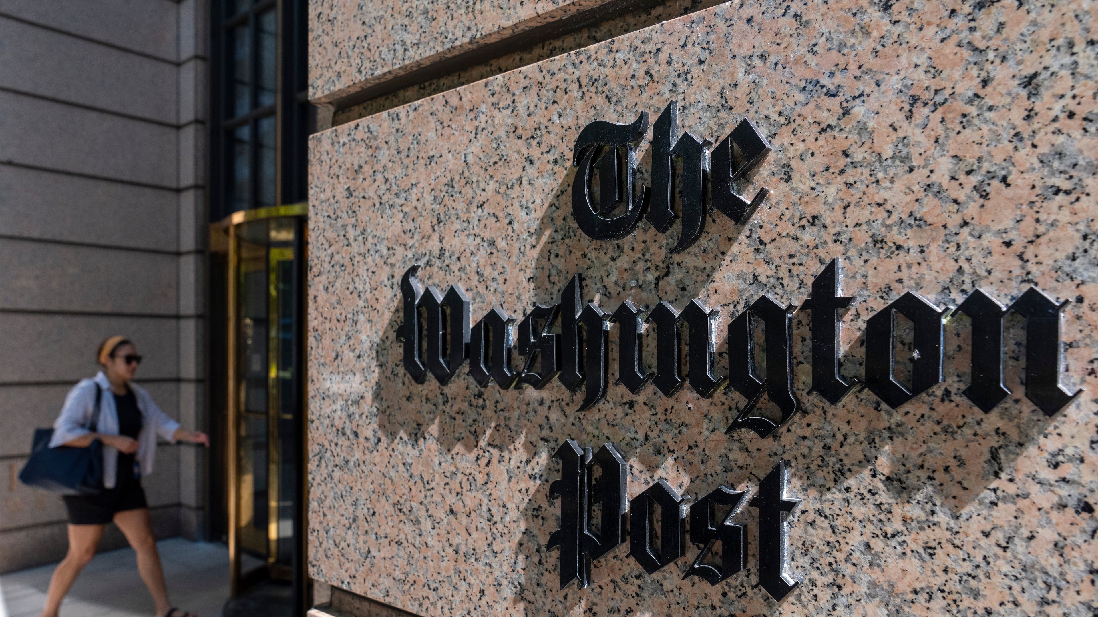 FILE - A person walks into the One Franklin Square Building, home of The Washington Post newspaper, June 21, 2024, in Washington. (AP Photo/Alex Brandon, File)