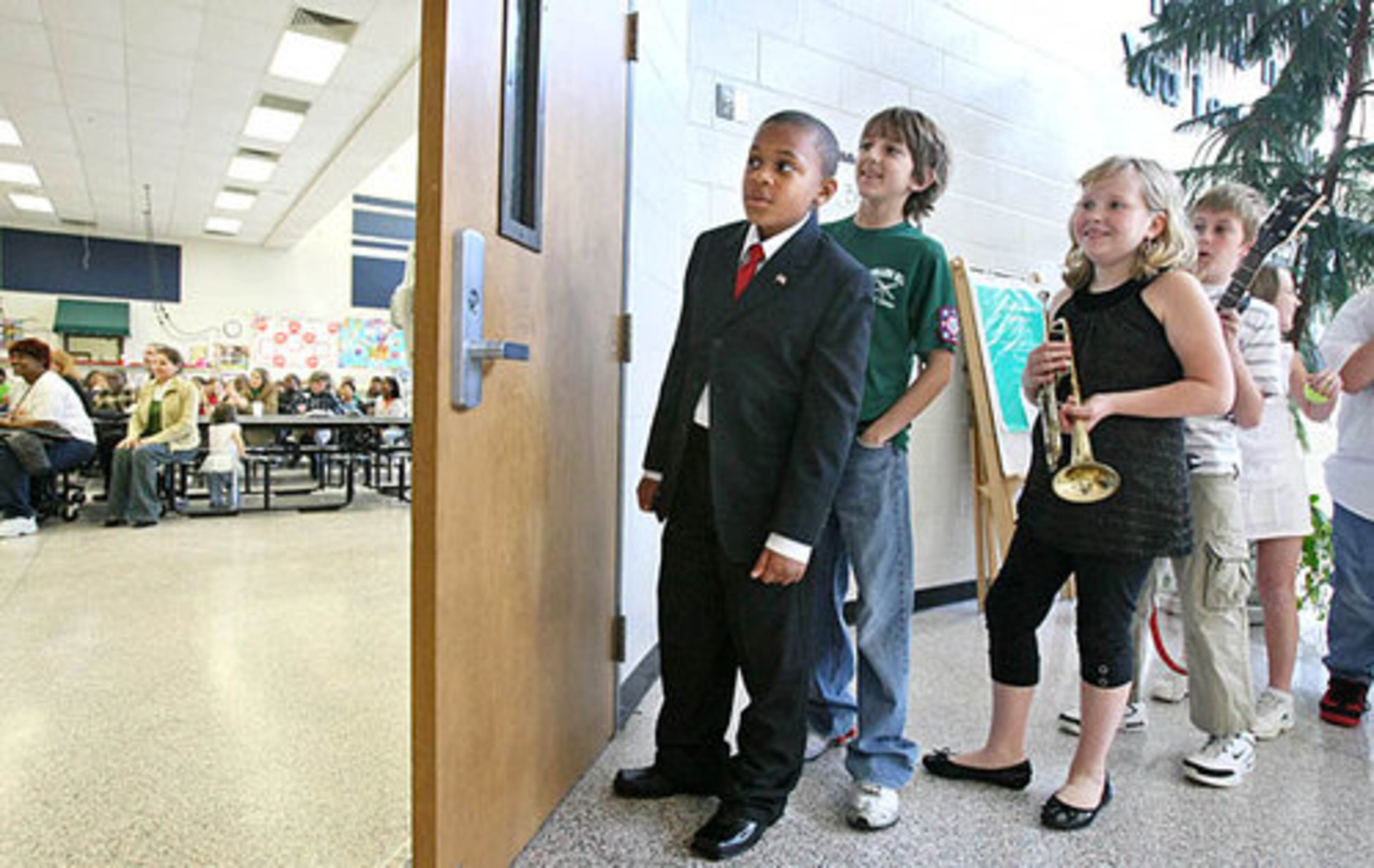 Brandon Sampson, 10, portraying U.S. President Barack Obama, in suit, waits with other classmates before going into the school's cafeteria for Jeff Trebich's 5th grade class presentation.