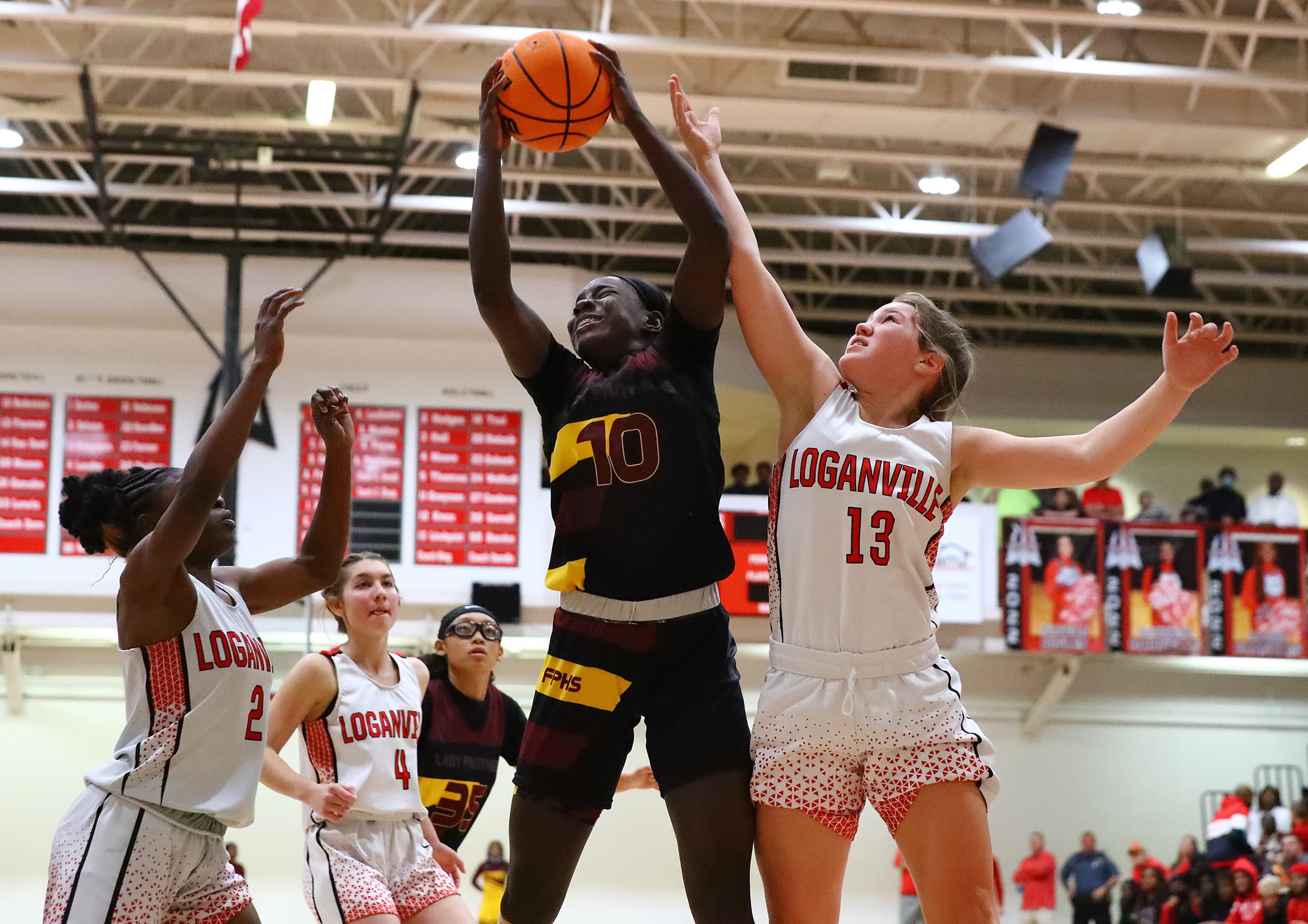 Forest Park guard Jayda Brown wins the rebound battle against Loganville forward Sophie Farmer in their high school basketball tournament game on Wednesday, March 2, 2022, in Loganville. “Curtis Compton / Curtis.Compton@ajc.com”`