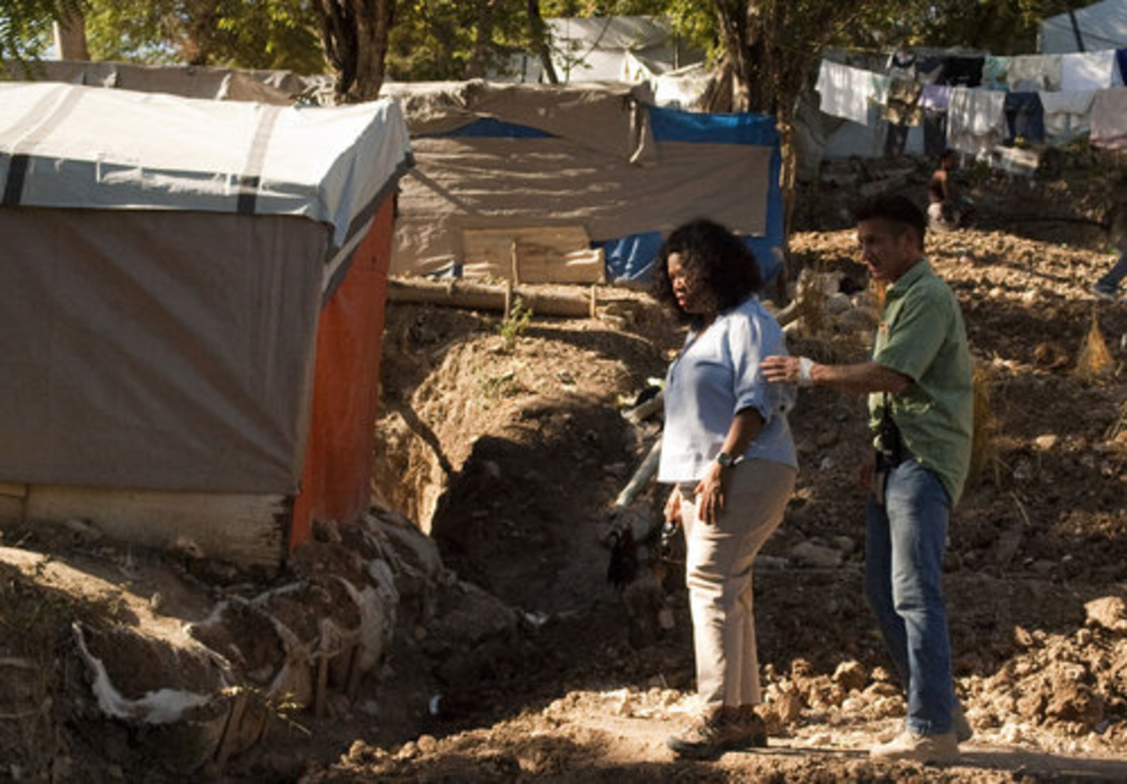 Tents housing those displaced by the 2010 earthquake surround Oprah Winfrey and Sean Penn as they stand at the settlement camp run by Penn and his aid group J/P HRO.