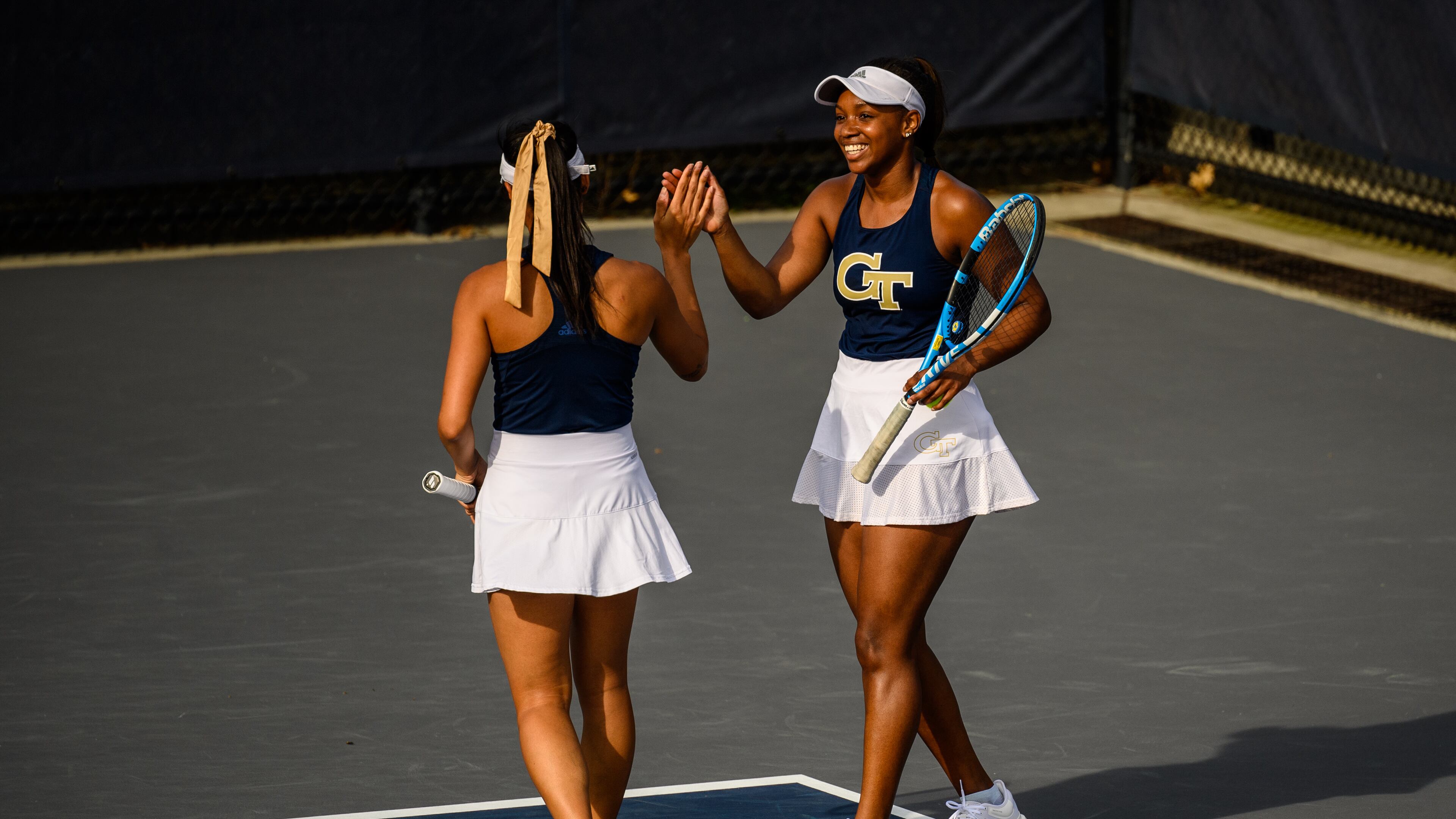 The Georgia Tech doubles team of Victoria Flores (facing away from camera) and Kenya Jones at the Yellow Jackets' match against Duke March 12, 2021 at the Byers Tennis Complex. (Danny Karnik/Georgia Tech Athletics)
