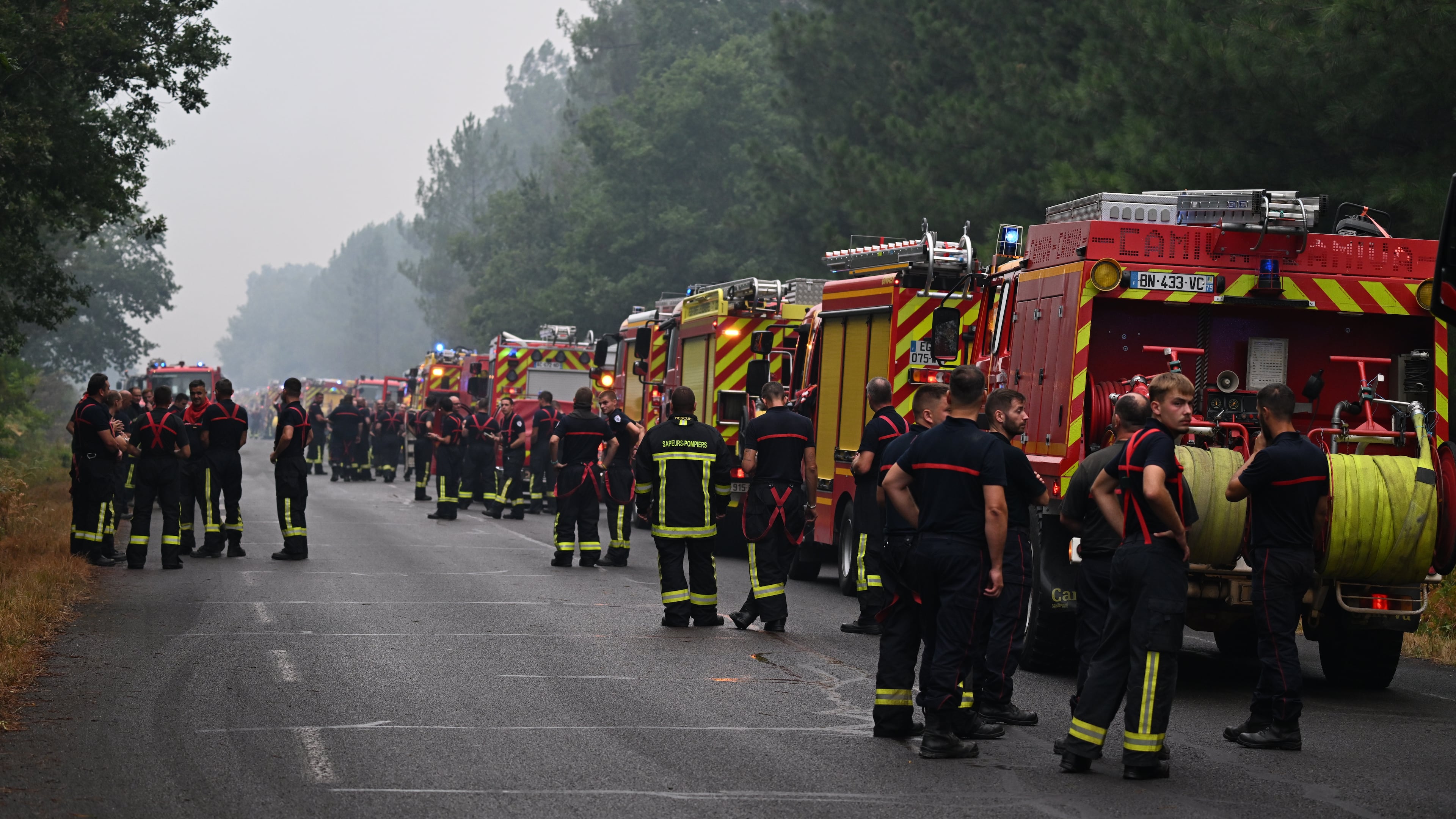 Firefighters wait on a road near Lacanau, southwestern France, Saturday, July 25, 2026. (AP Photo/Emma Da Silva)
